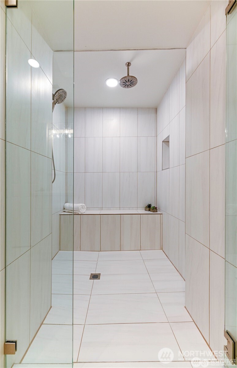 This custom designed spa shower is complete with multiple showerheads, custom lighting and glass door, built in shower bench and tiled floor and walls - offering a relaxing, spa-like experience right at home.