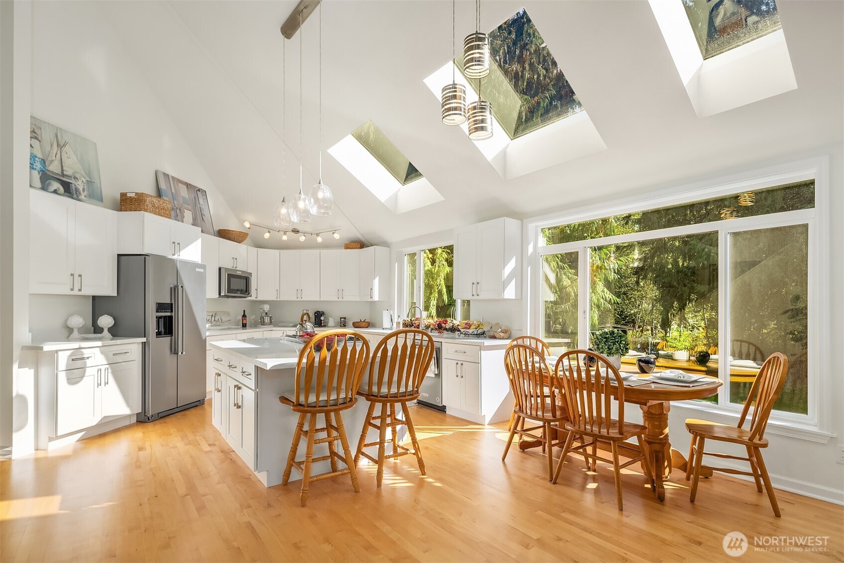 This gourmet kitchen features all-new custom cabinetry, sleek quartz countertops, stainless steel appliances, custom lighting, rich hardwood floors and a custom island that offers a generous space for food prep, casual dining, and effortless entertaining.