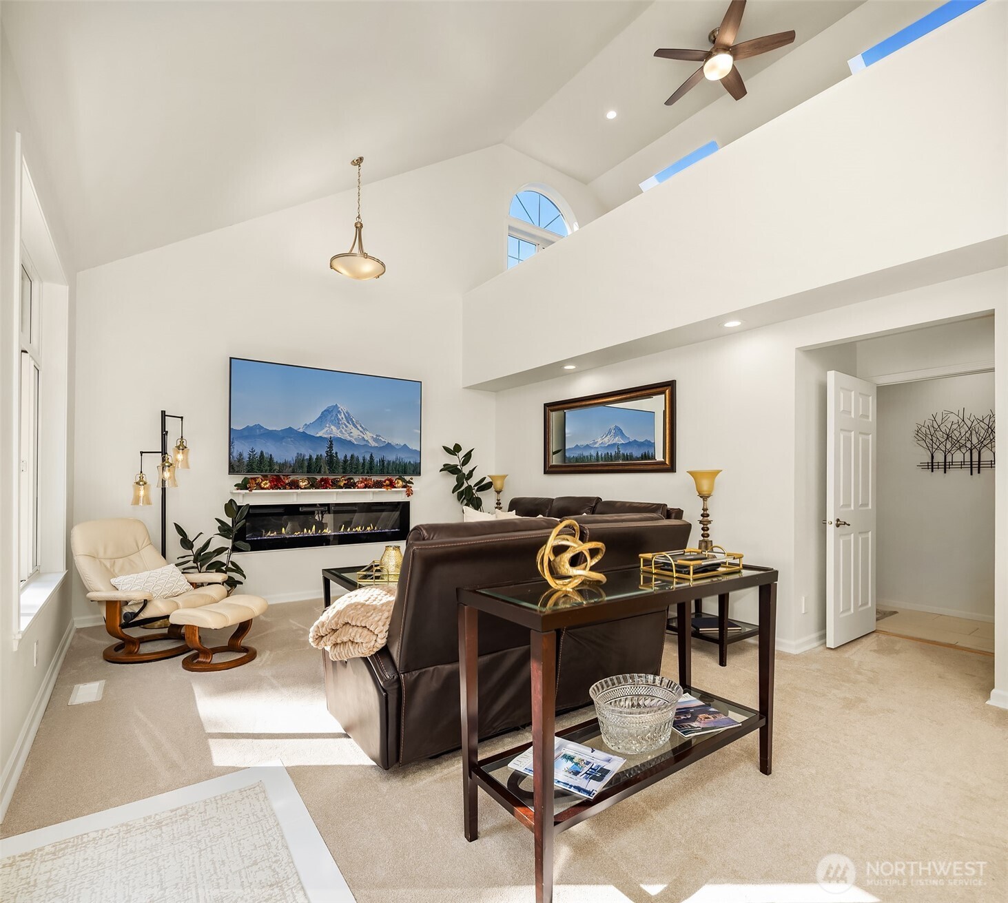 Bright and inviting family room with soaring 25 foot vaulted ceilings, full to ceiling windows for natural lighting, and an open, airy feel - perfect for relaxing or entertaining.
