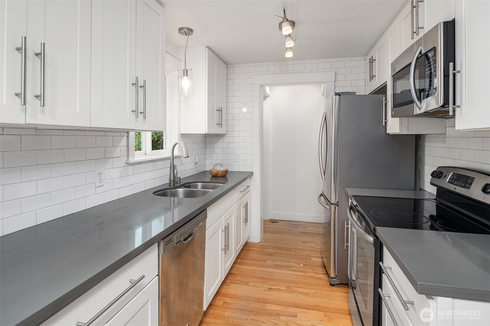 Updated kitchen with stylish countertops, subway tiling and bright cabinetry. Enough space to multitask during meal preparation.