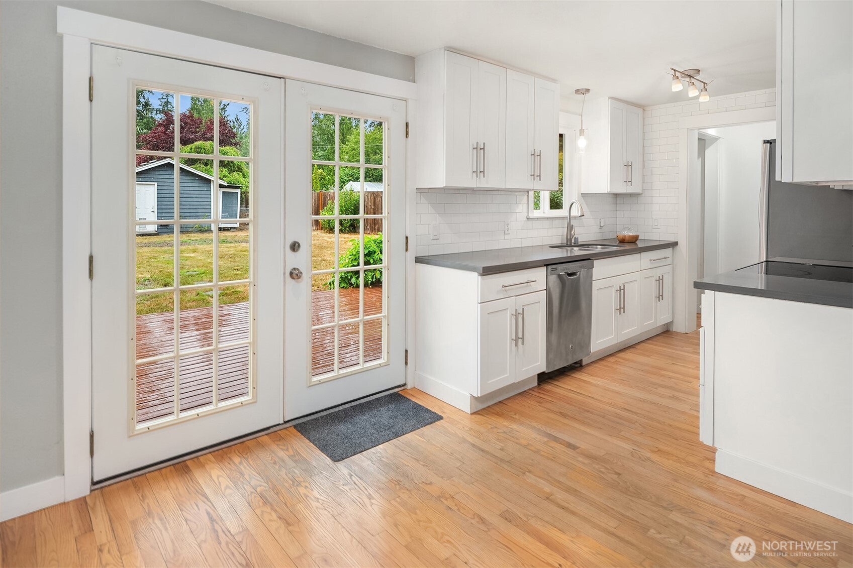 French dprovide access between the dining room and the low to ground deck in the grassy back yard. Whether you are barbequing outside and bringing food in, or preparing food inside to take out, you have wide doorway access for multiple people and pets.