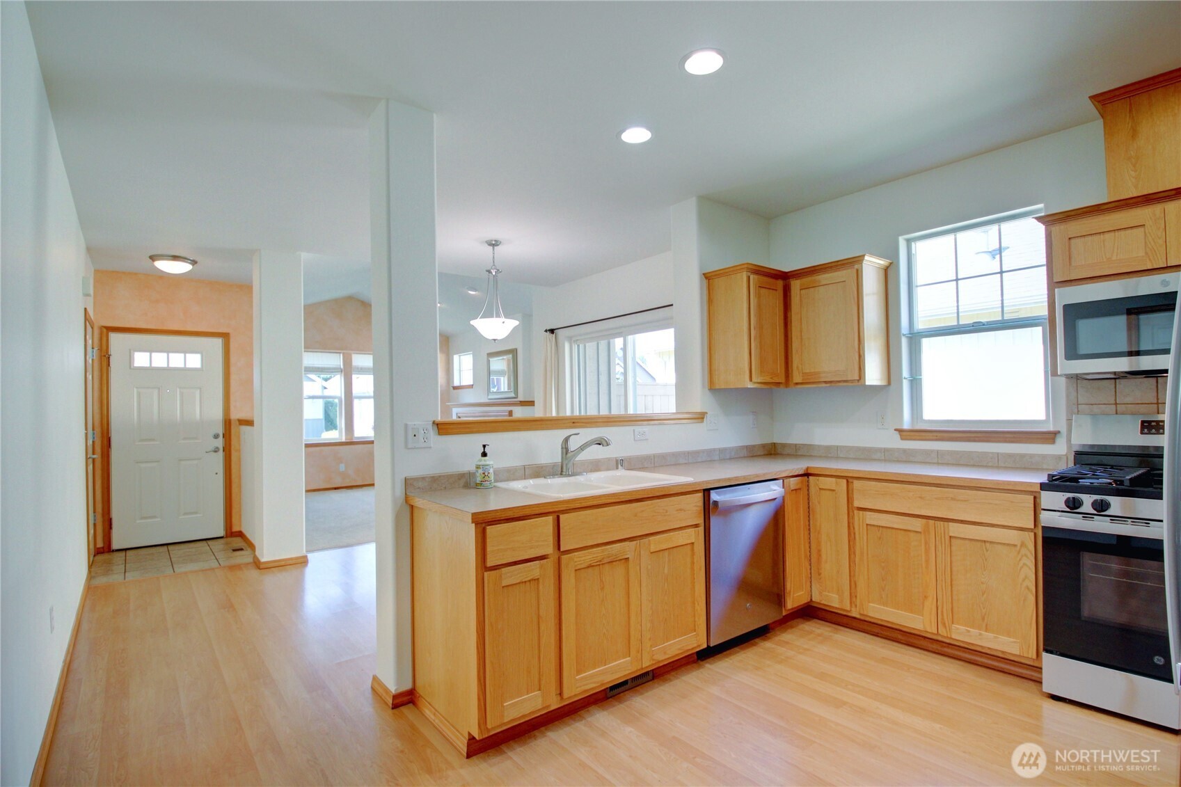 Oak wood cabinets have been refinished and are in pristine condition.