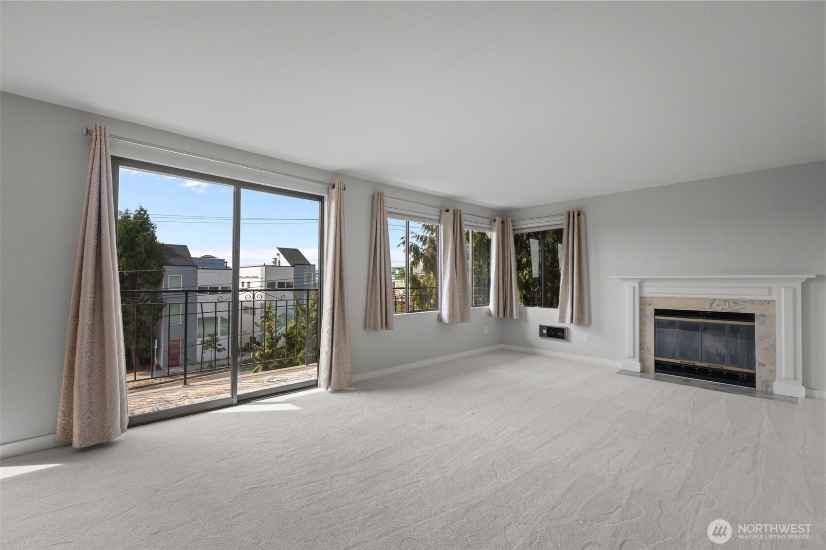 Bright open living room with cozy wood-burning fireplace and large windows