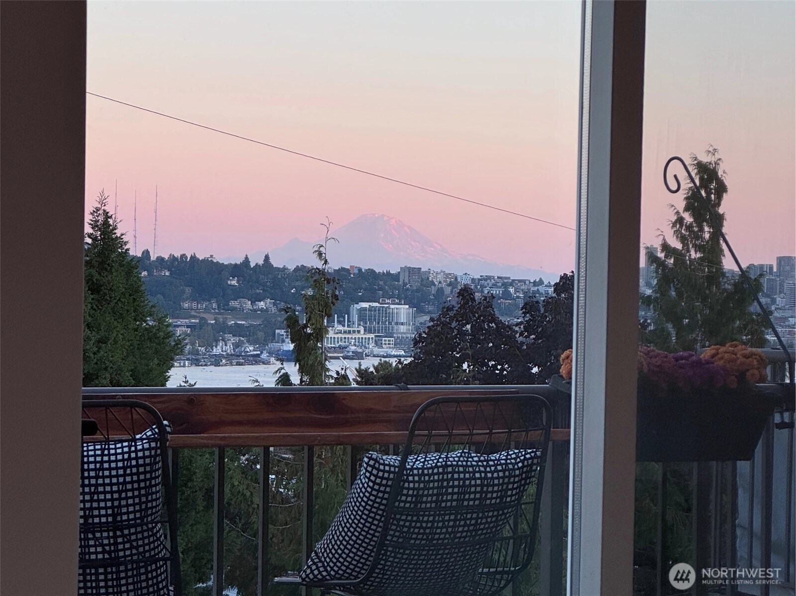 The living and dining areas are wrapped in natural light, seamlessly connecting to the balcony