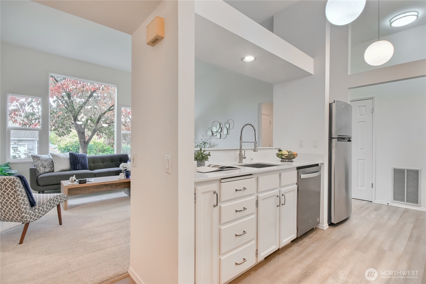 Front of condo with high windows, awning, nice patio. and garden space.