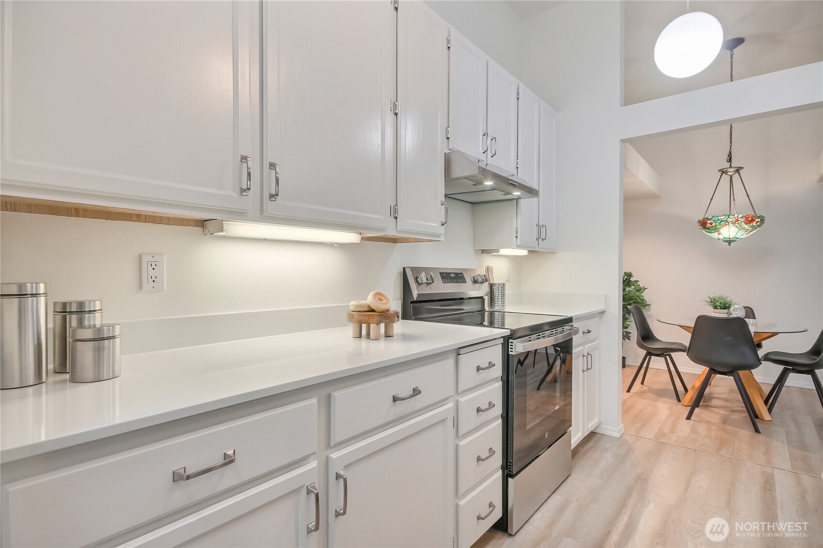 Updated Kitchen with all new stainless appliance suite, faucet, sink, hardware, luxury vinyl plank floors and granite slab countertops.