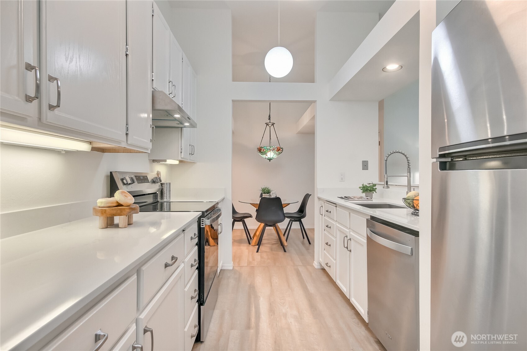 All new appliances in this galley kitchen with granite countertops and new hardware.