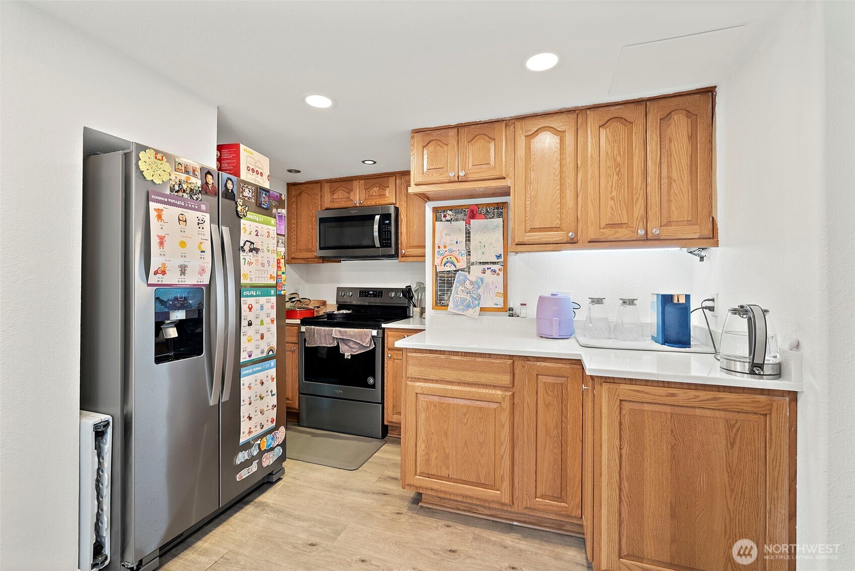 Kitchen with stainless steel fridge, range and microwave.