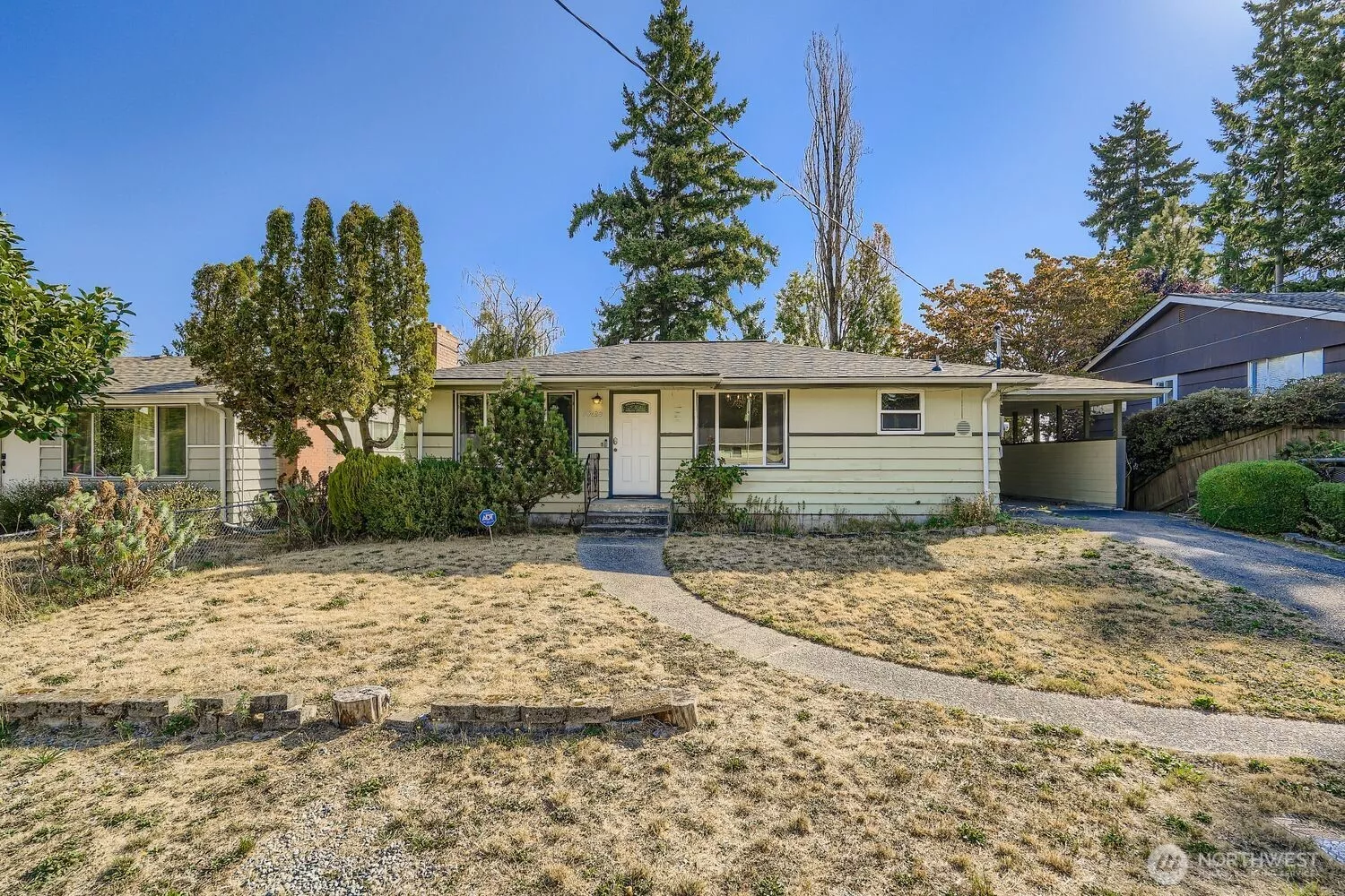 Street level approach to the west-facing front door and yard.