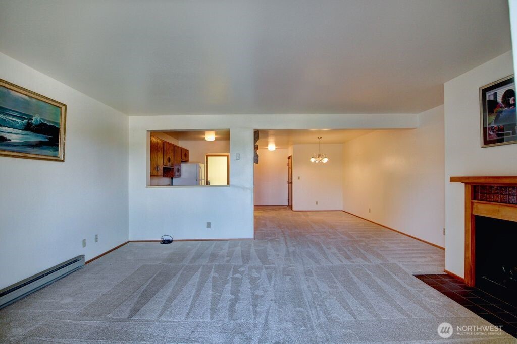 View of fireplace, kitchen and dining area from the corner of the living room.