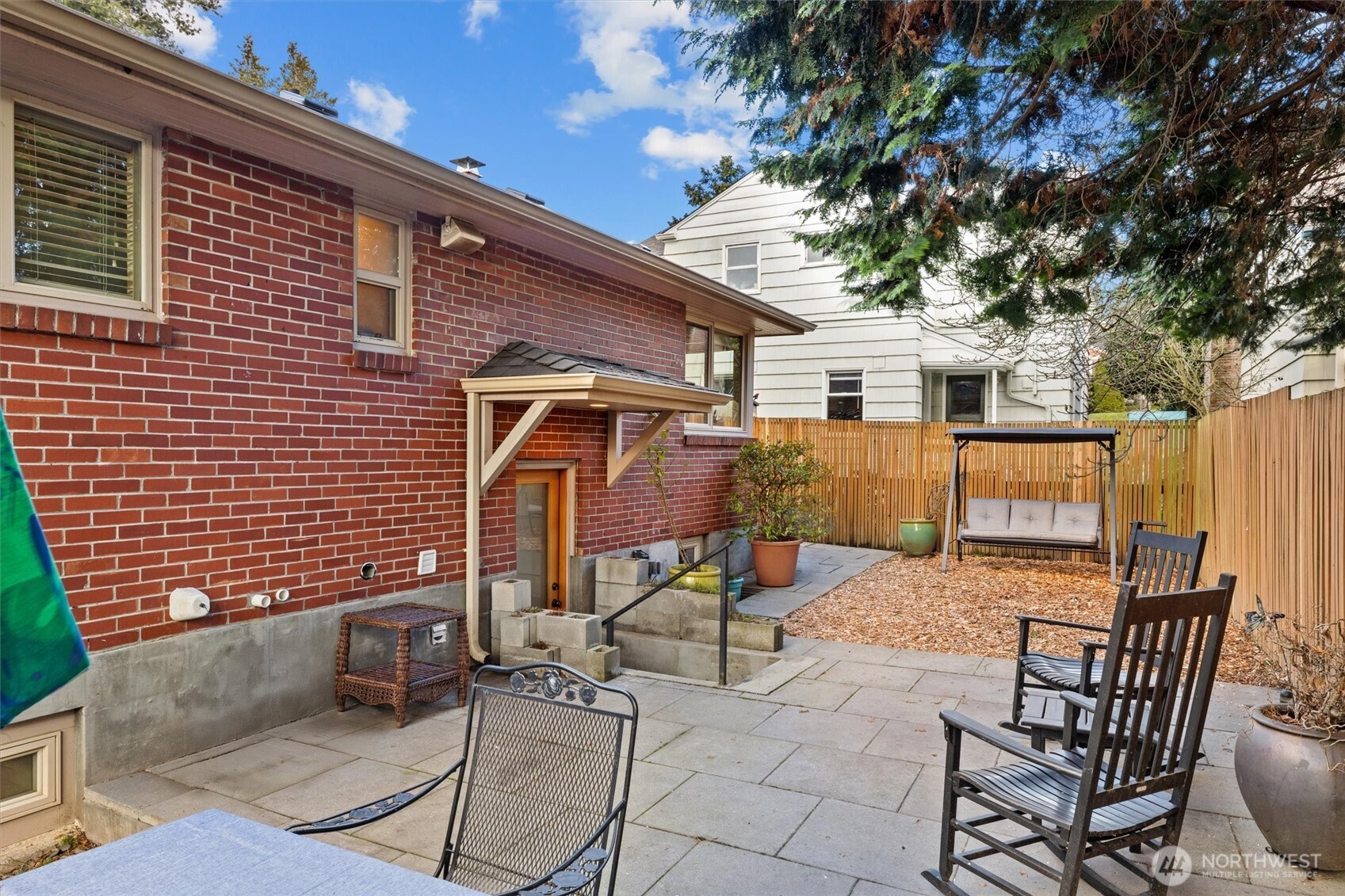 The back patio has defined areas with a paved patio for the cook and guests to relax in the south-facing sun.