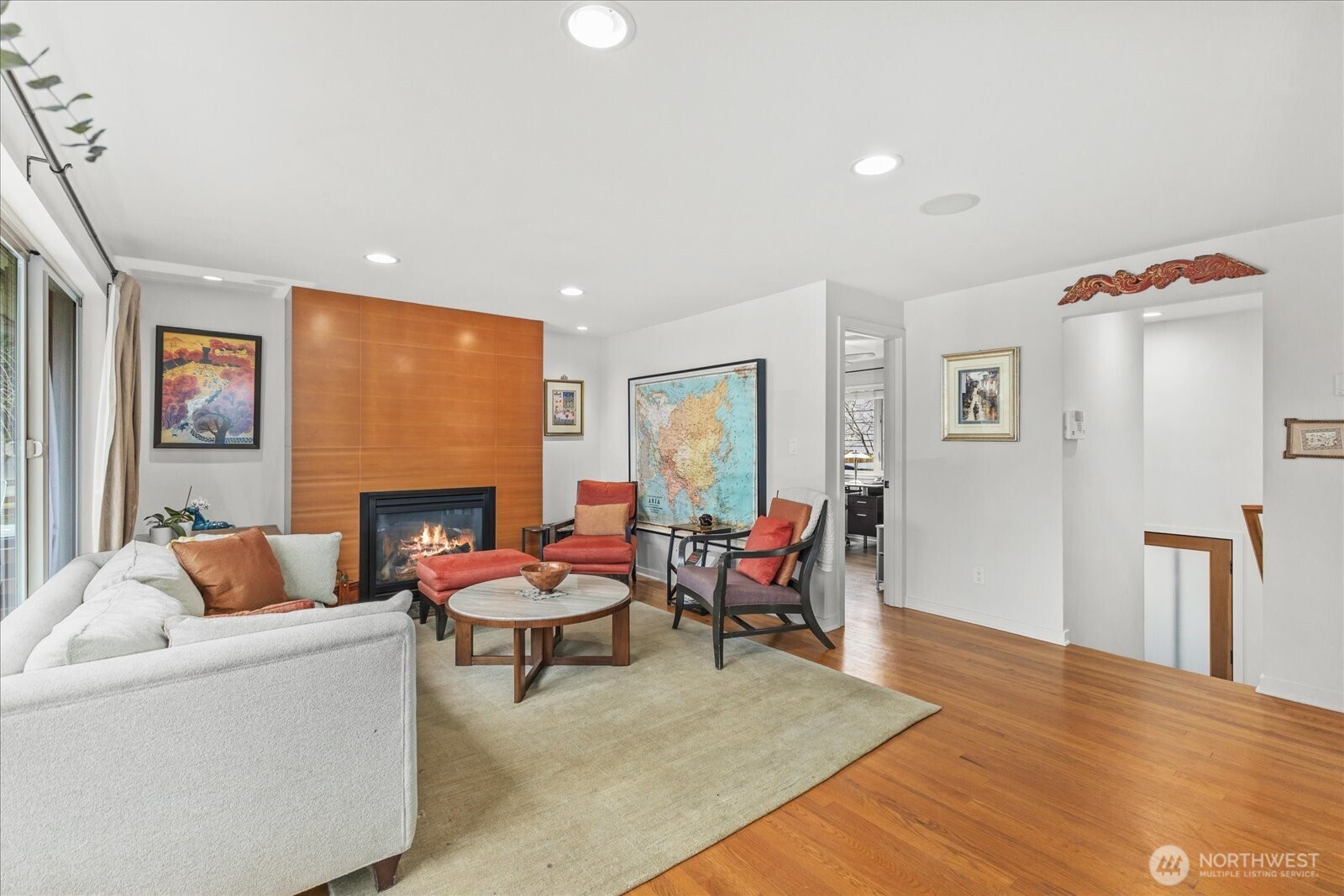 The living room features a wall of windows: picture window and sidelights with sliding hardware and screens for fresh air.