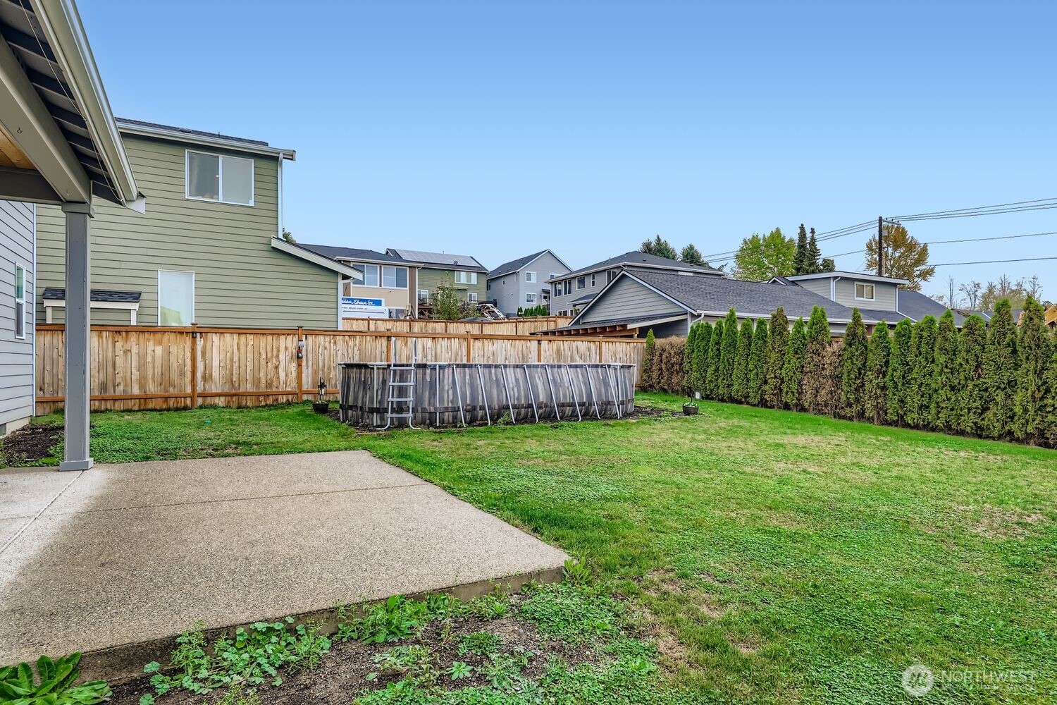Covered patio with outdoor fireplace, built-in BBQ, and wall-mounted TV.