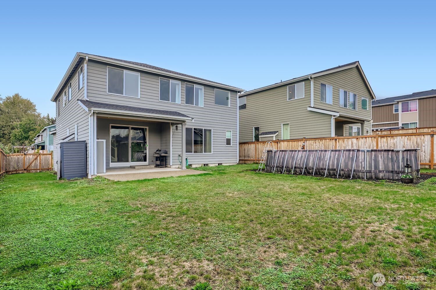Rear exterior view from backyard corner showing above-ground pool and home.