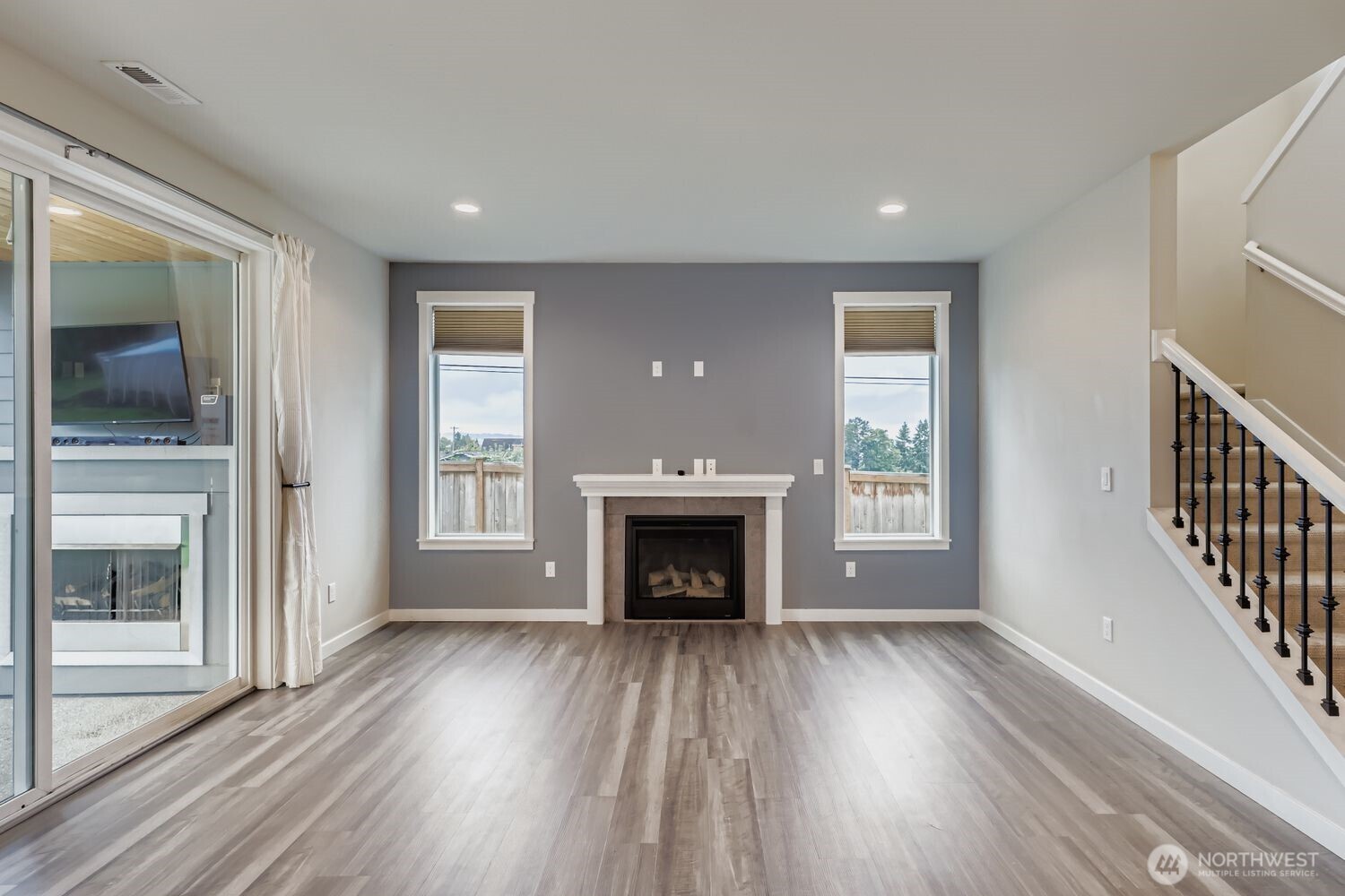 Open-concept great room with natural light and fireplace.