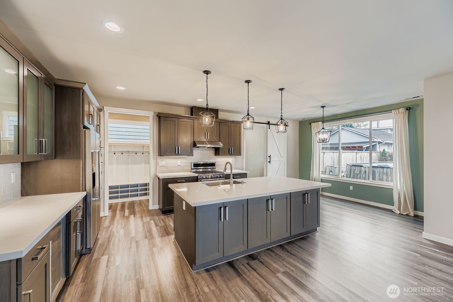 Modern kitchen with stainless appliances and large island.