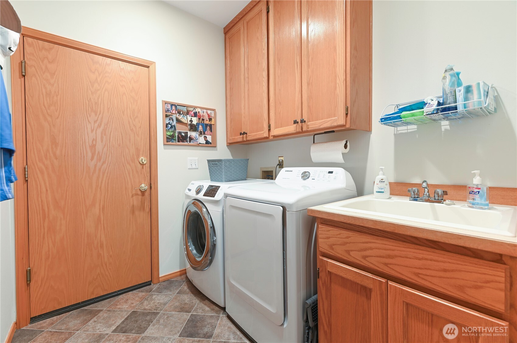 Main level laundry off the garage with utility sink abd cabinets. All appliances stay.