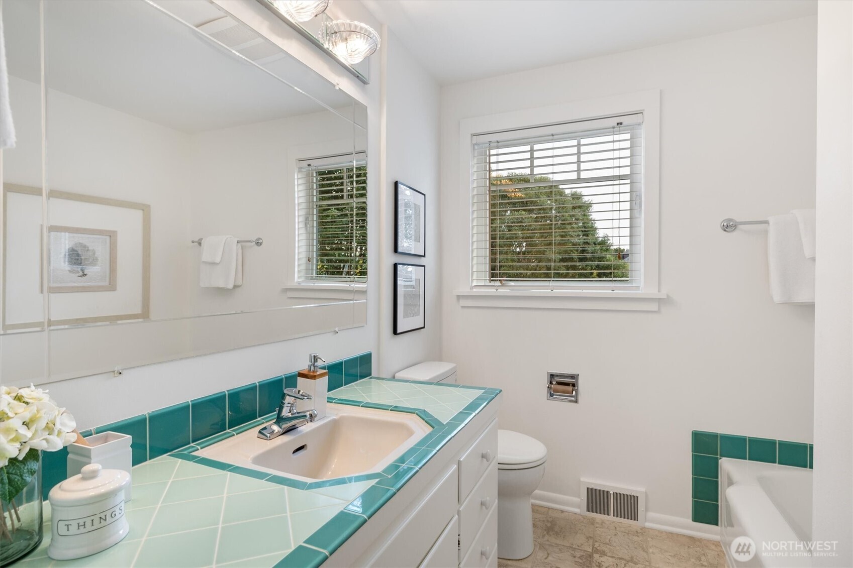 The main floor bath features both a tub and separate shower, with a layout spacious enough to accommodate a dual vanity. Classic tile accents and natural light give the space a fresh, functional feel.