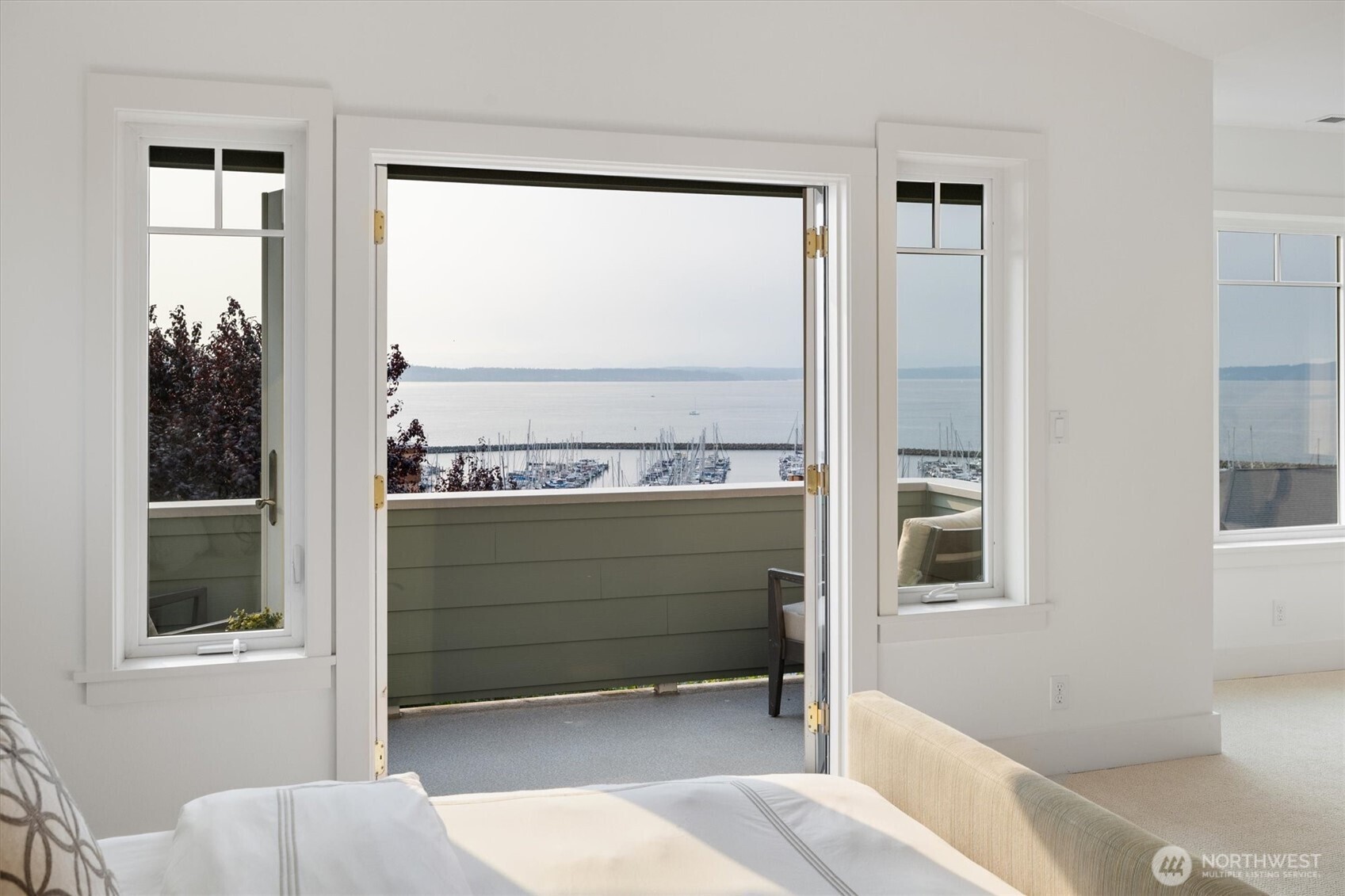 French doors open from the primary suite to a private balcony, where sparkling views of Shilshole Bay create a breathtaking backdrop for morning coffee or evening sunsets.