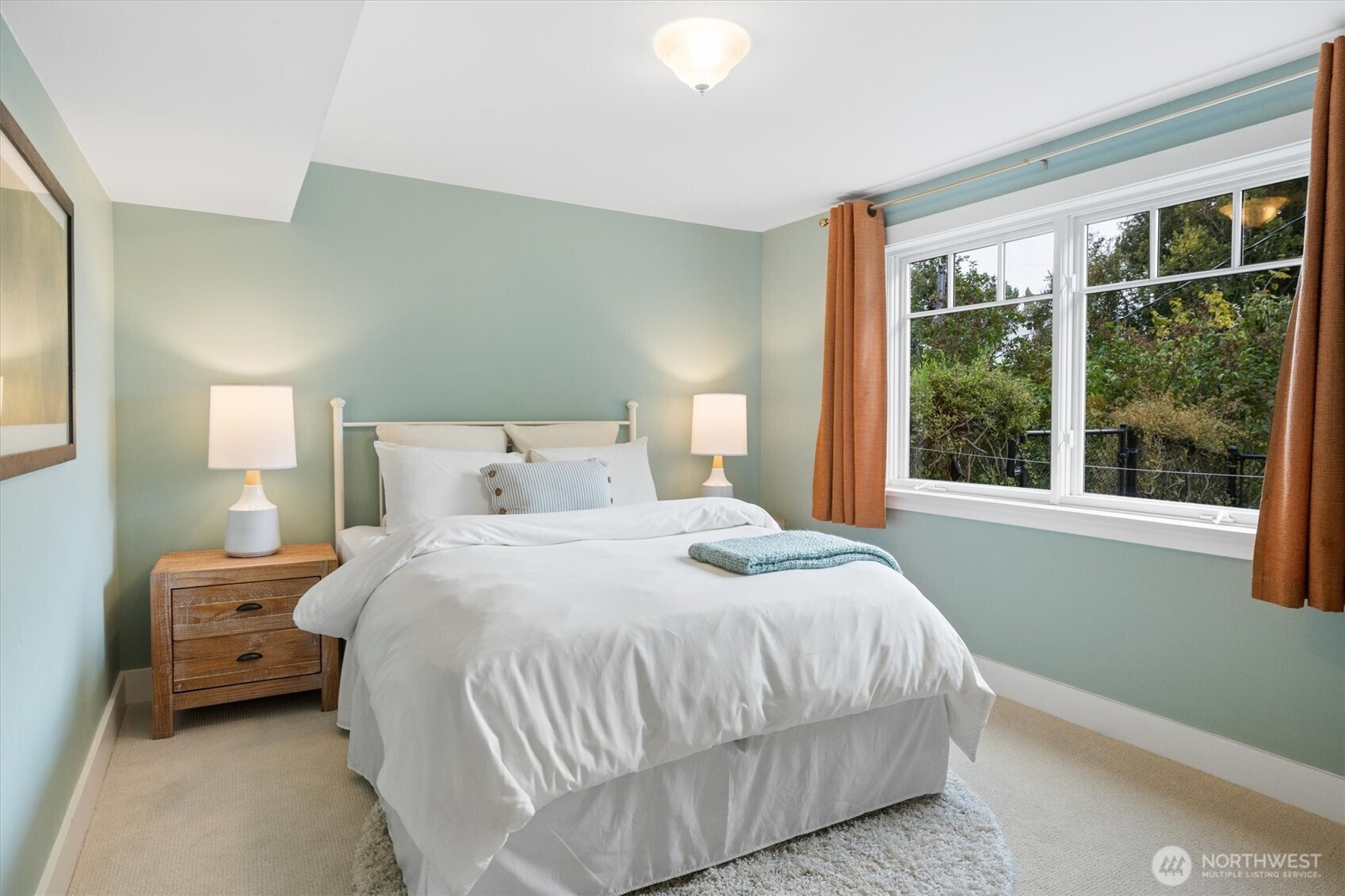 Bright and comfortable, this lower-level bedroom features a large window with garden views and ample natural light—an inviting retreat for overnight visitors or extended stays.