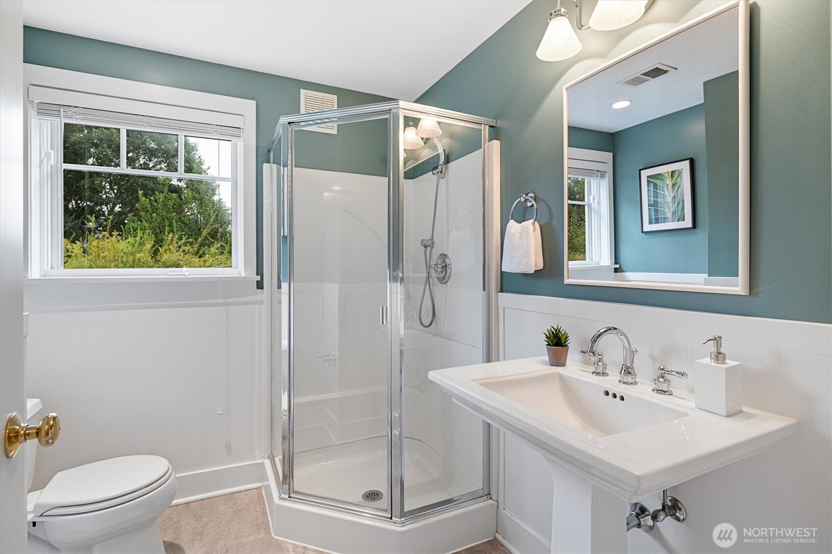 A bright and functional ¾ bath with walk-in shower and pedestal sink serves the lower level, creating a convenient private suite feel when paired with the adjacent guest bedroom.