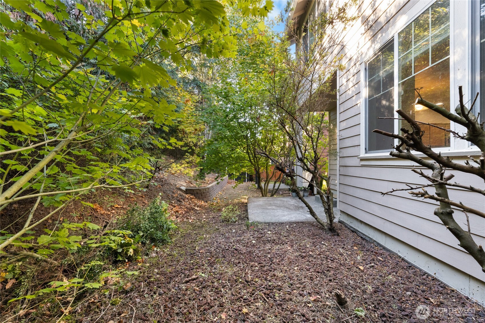 Backyard with covered patio. There is no lawn to mow here as the flower bed is mostly of decorative lava rock (pebbles)