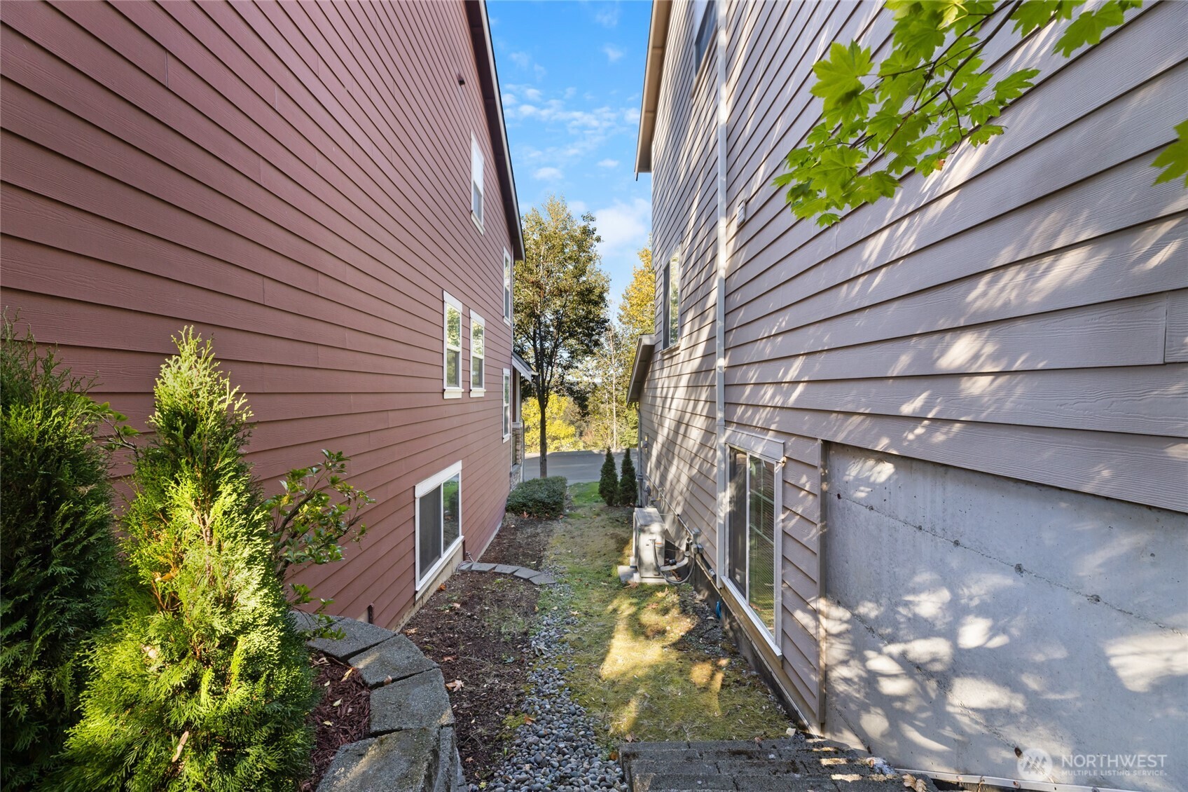 From the side of the yard looking towards the west, notice the heat pump on the side of the house. There are stairs leading from the patio to the side yard