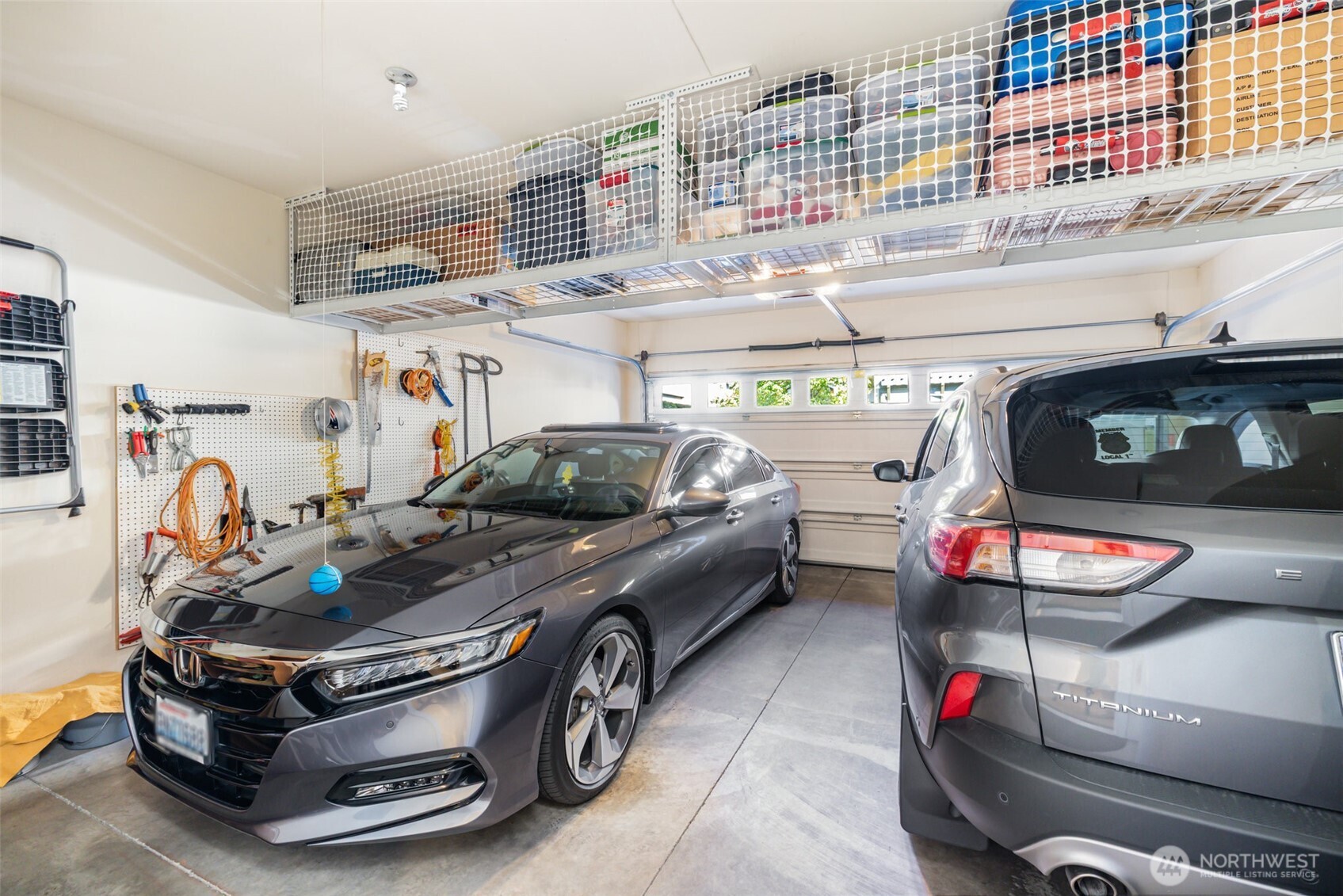 2-car garage has clever overhead built-in storage & hose hook up.