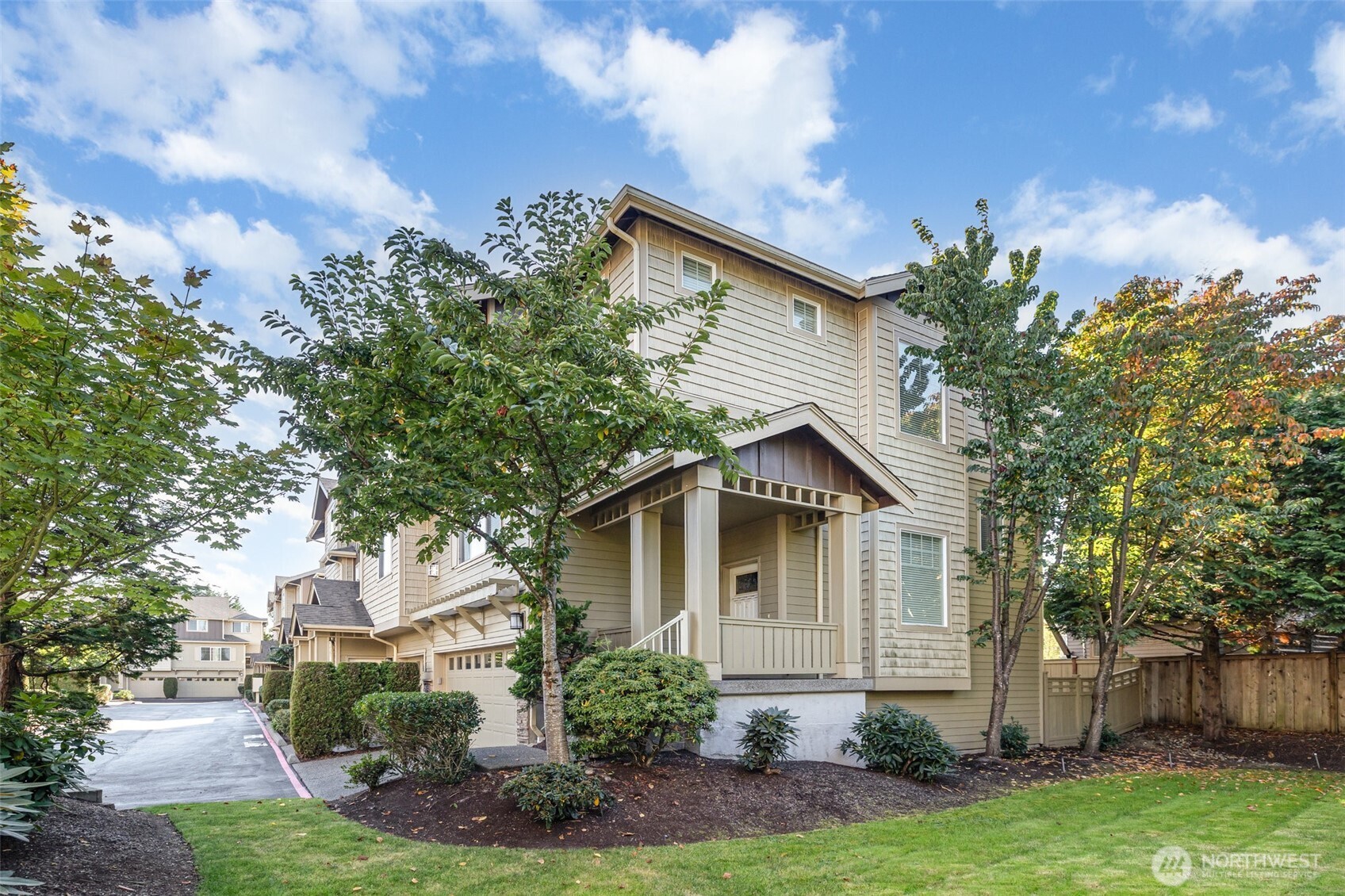 Another view from the grassy area, showcasing the abundance of trees and mature landscaping.