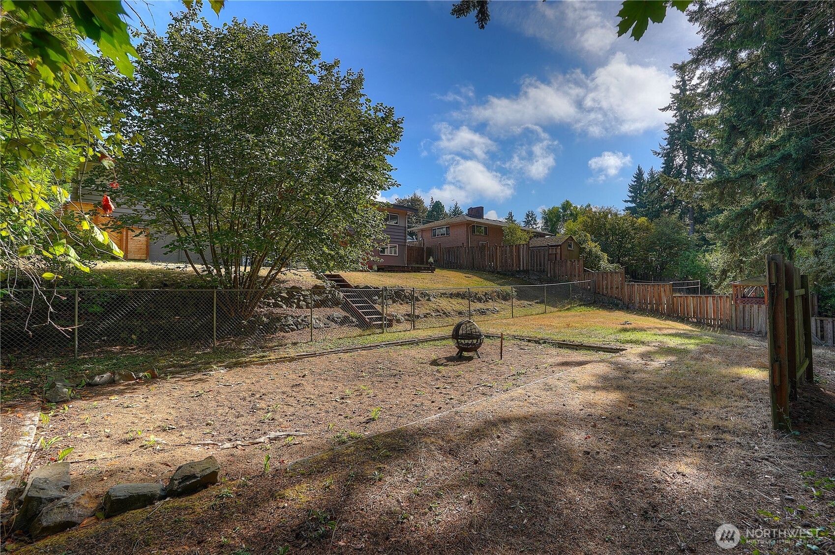 Lower terrace view of the yard with the old sand pit area perhaps used for game of horseshoes at one time, but totally adaptable for several uses…