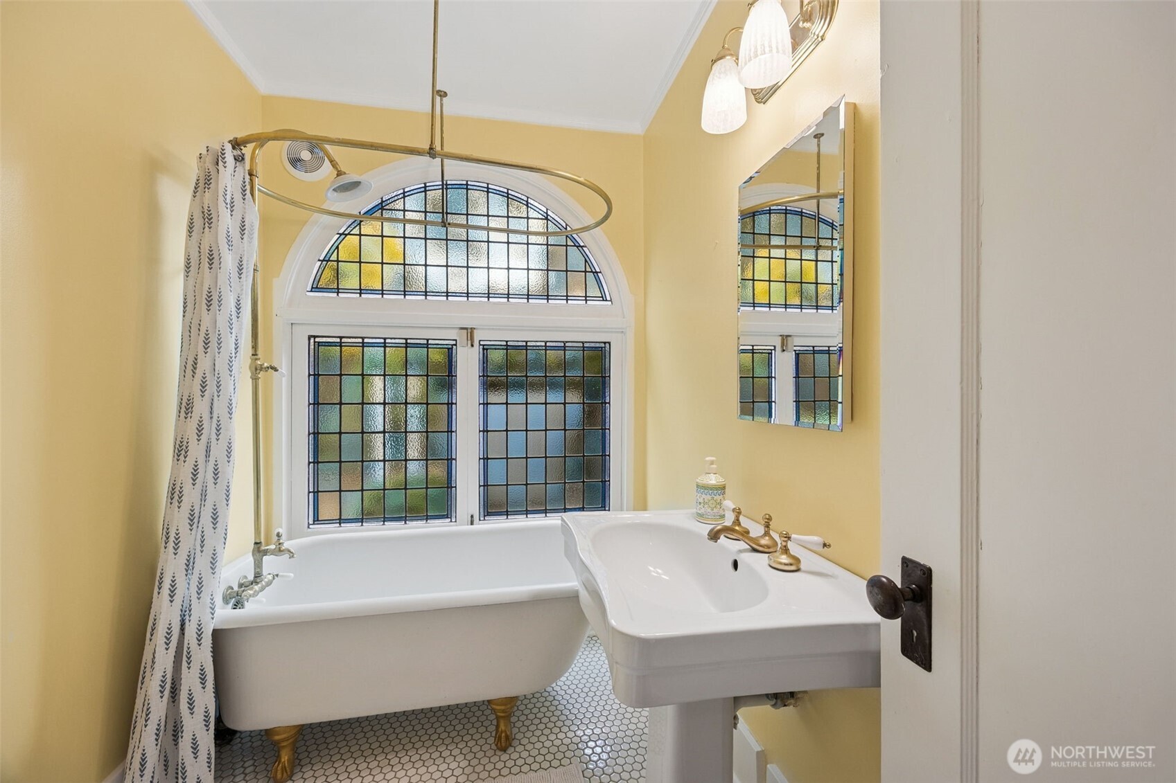 The clawfoot tub and dramatic window are just a few of the period details seen throughout the house.