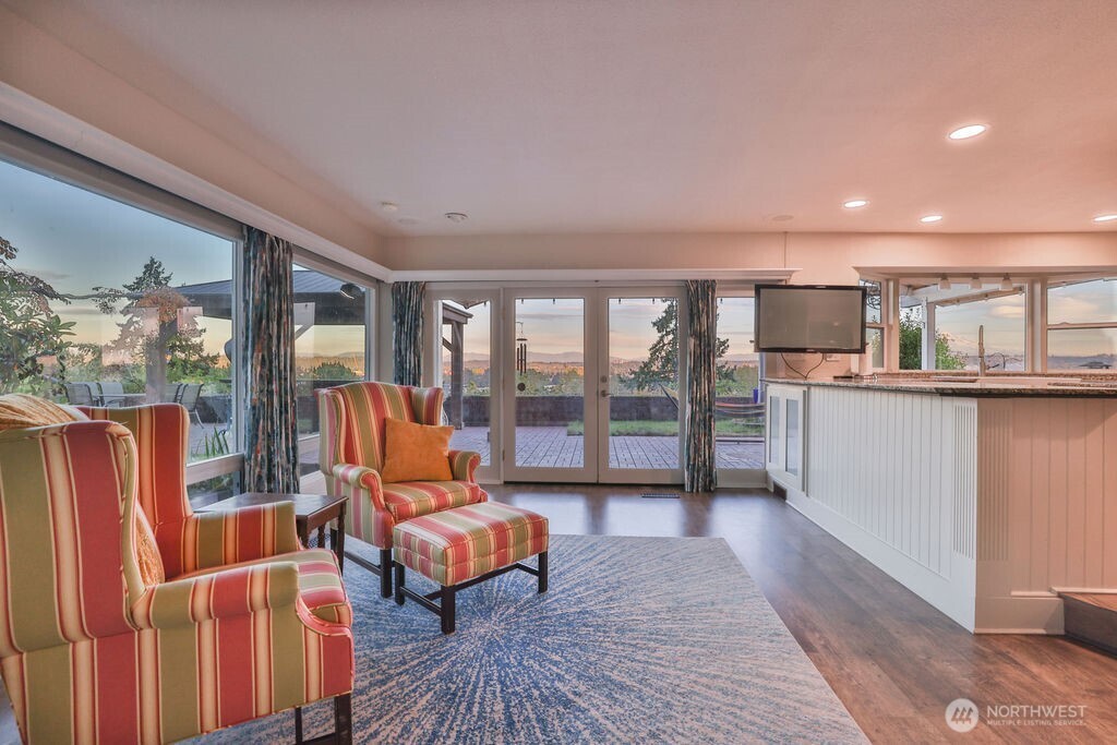Living room with wall of windows allowing in natural light throughout the house