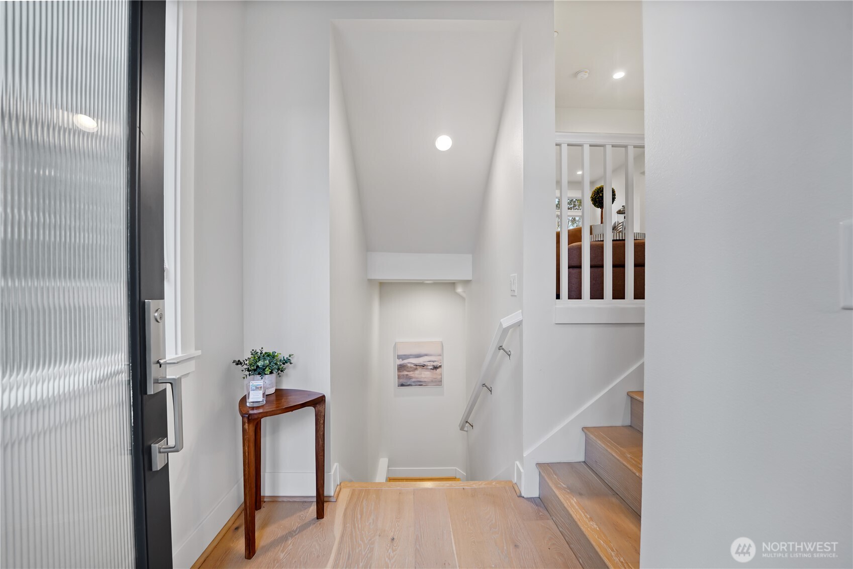 The entry welcomes you with access to the garage (downstairs) and a convenient bedroom tucked just beyond.  The stairs lead gracefully upward to the main living area, where light and comfort await.