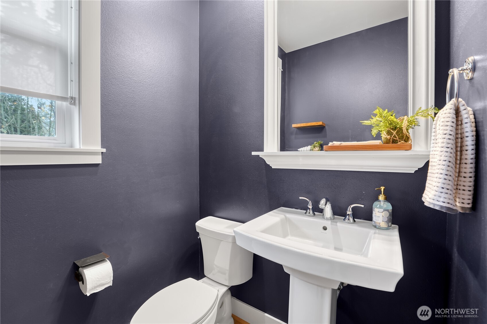 The powder room makes a bold statement in its original navy blue, beautifully contrasted by crisp white fixtures.