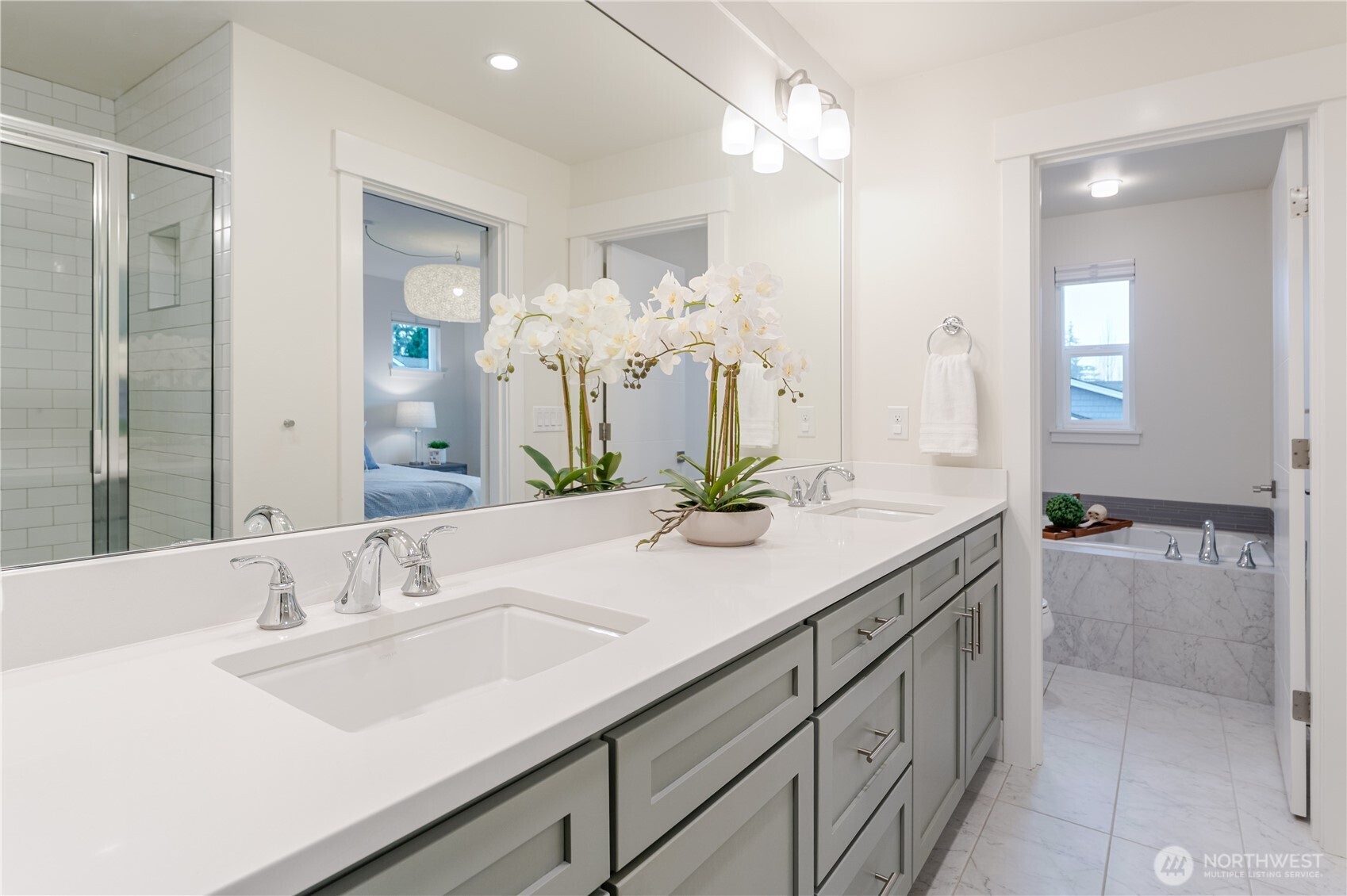From the double sinks, the view extends to the inviting soaking tub, a perfect retreat for relaxation.