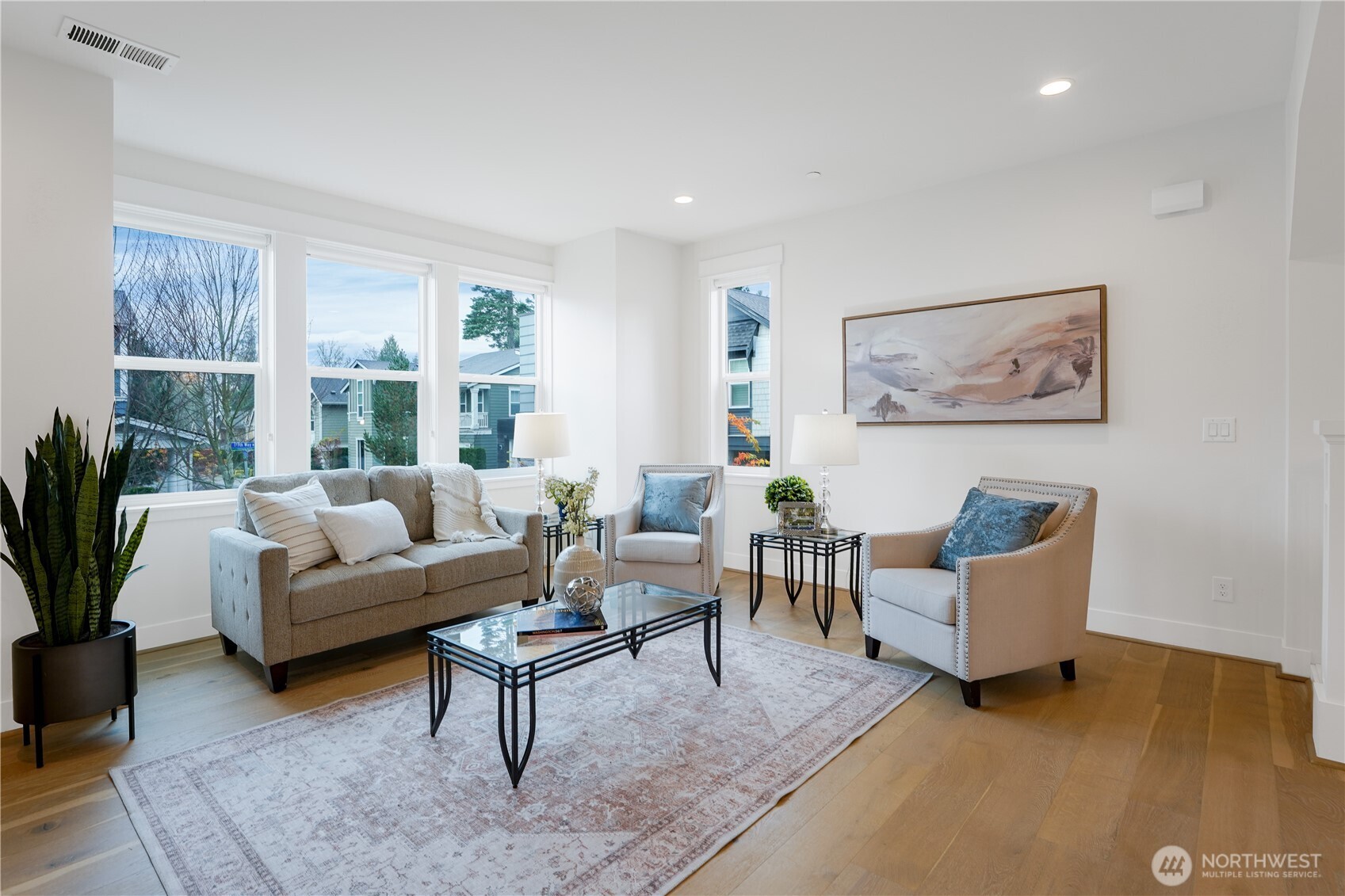 In the family room, tall ceilings and abundant natural light create an airy, welcoming centerpiece for daily living.  This great room is the hub of the home with the kitchen and dining area nearby.  The entire home has been freshly painted and the hardwood floors flow seamlessly throughout for a timeless look