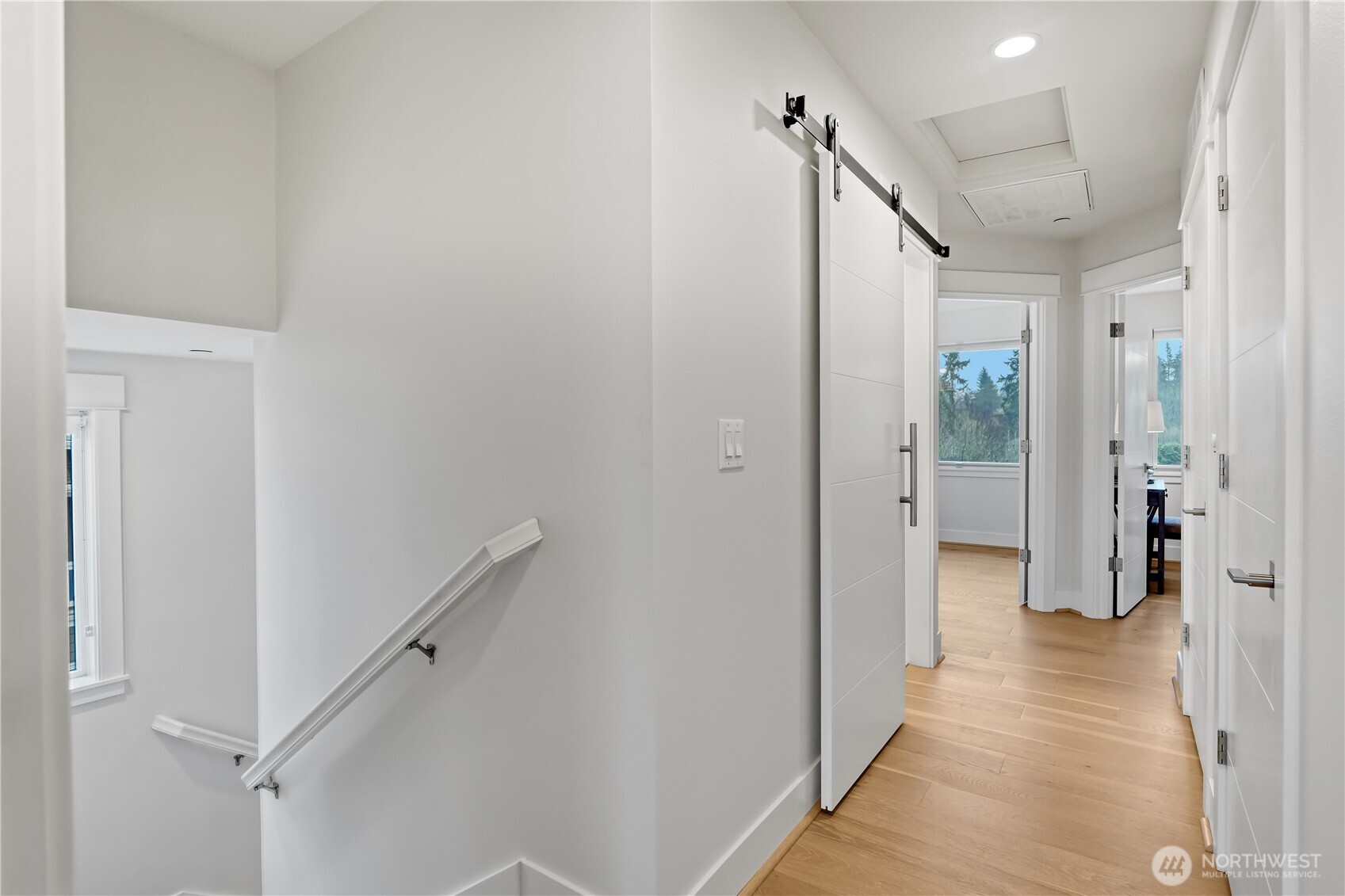 From the entry to the primary suite, the upstairs hallway offers a bright, open view of the home’s upper level.