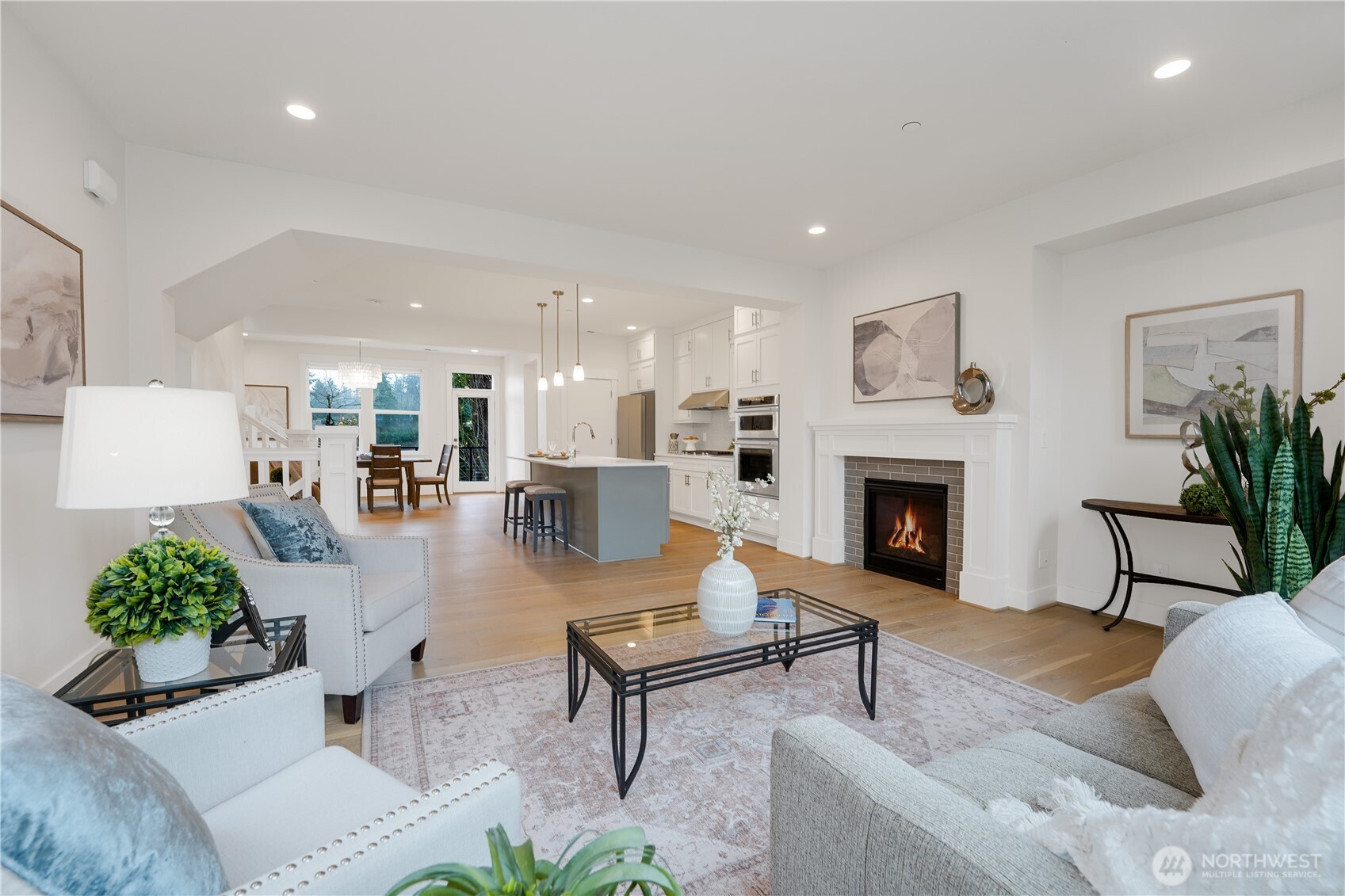 From the living area, the open concept design flows seamlessly toward the kitchen and dining space beyond.