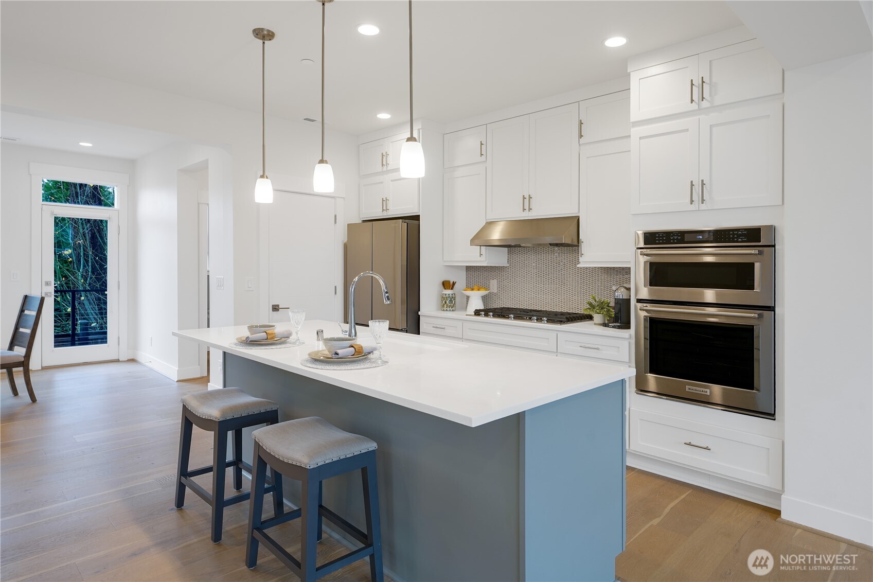 A large blue center island anchors the space, offering both seating and a stylish focal point.