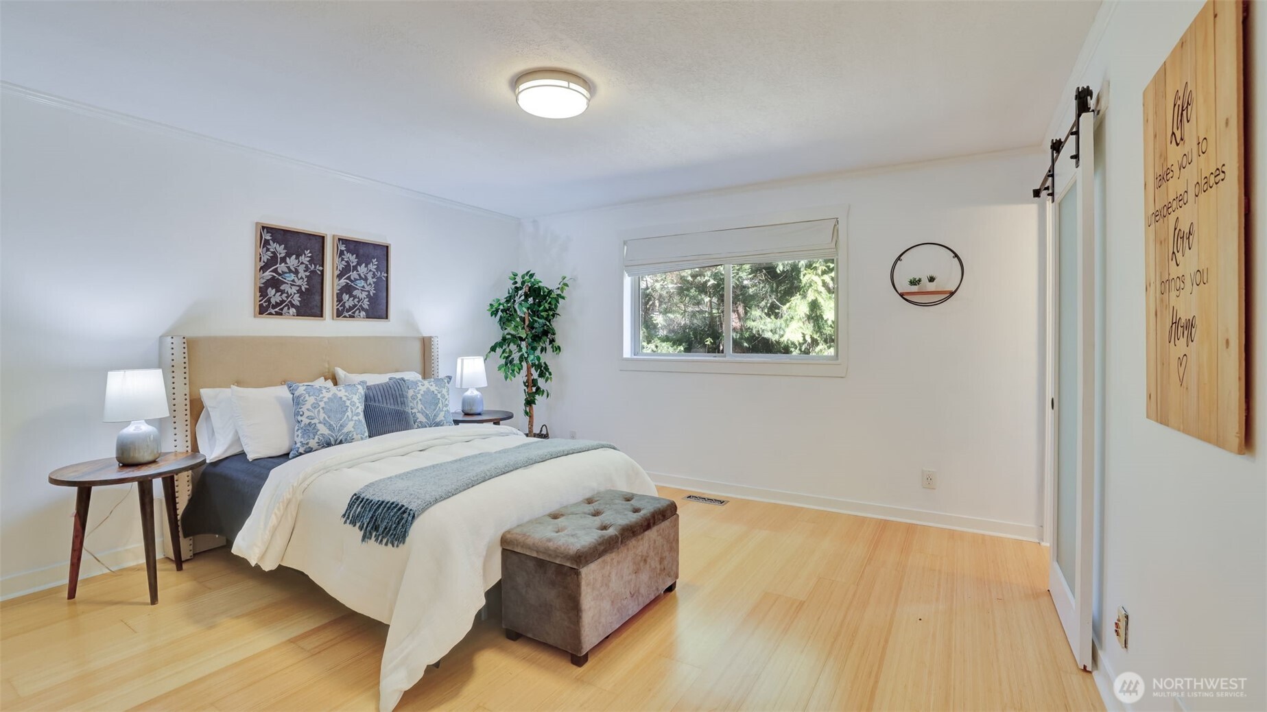 Upstairs primary bedroom retreat designed for comfort, featuring spacious layout and elegant wood floors.