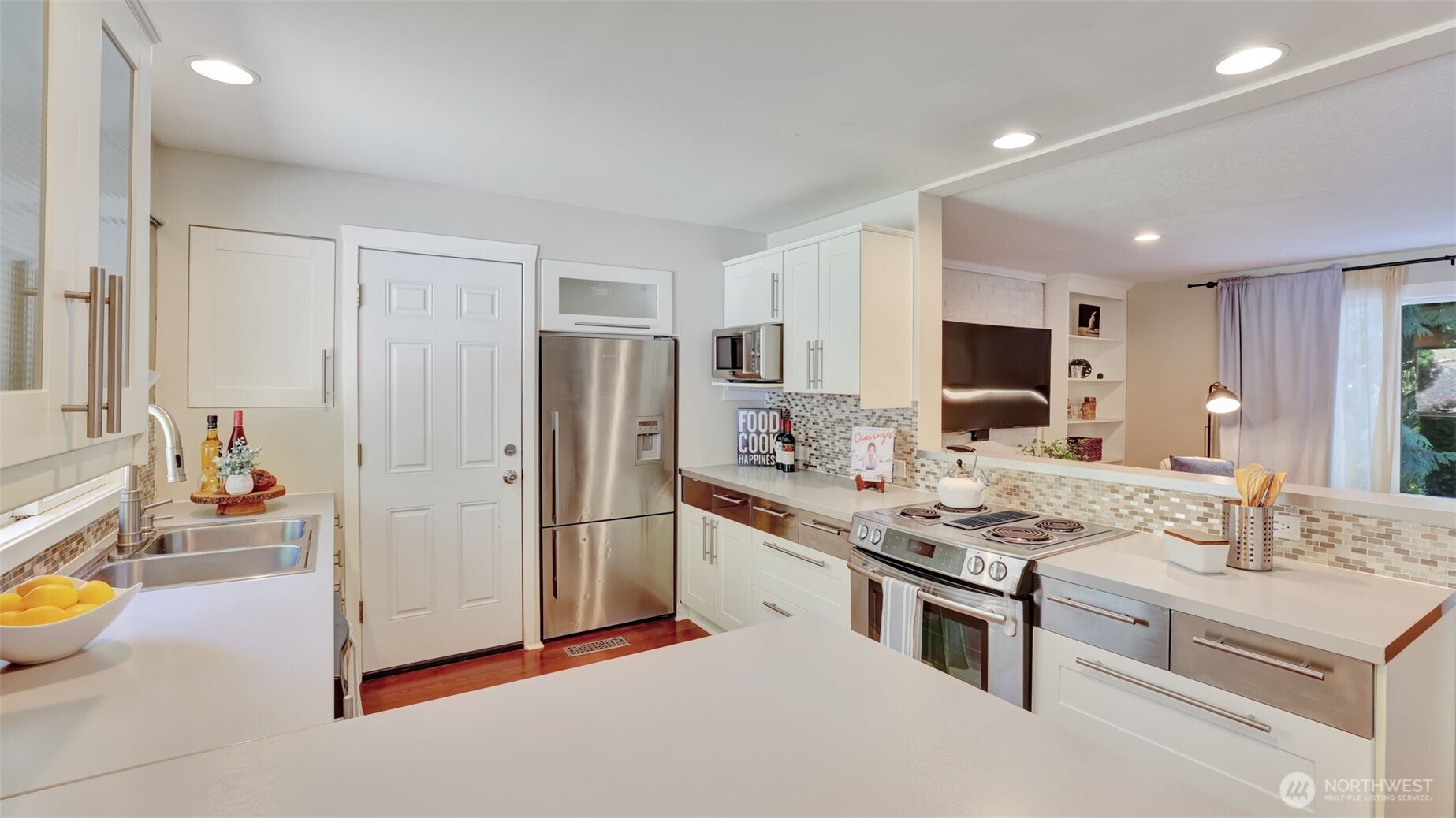 A light filled culinary space with sleek white cabinetry and seamless garage access.