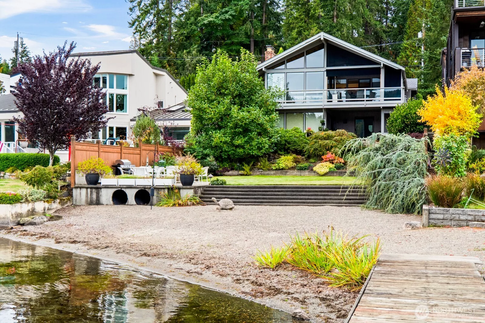 Experience resort-style living in this stunning waterfront retreat. Walls of windows and tiered landscaping showcase panoramic lake views