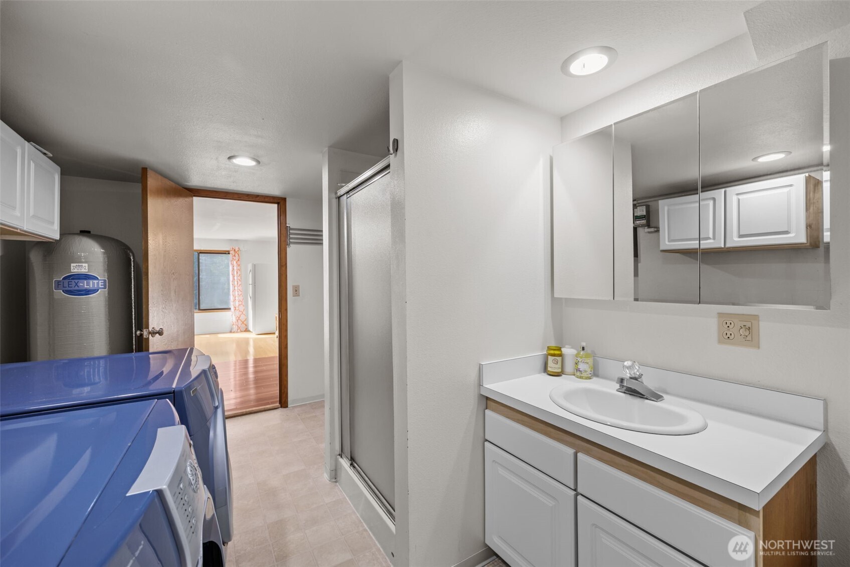 Downstairs 3/4 bath with laundry, hot water tank and cabinets.