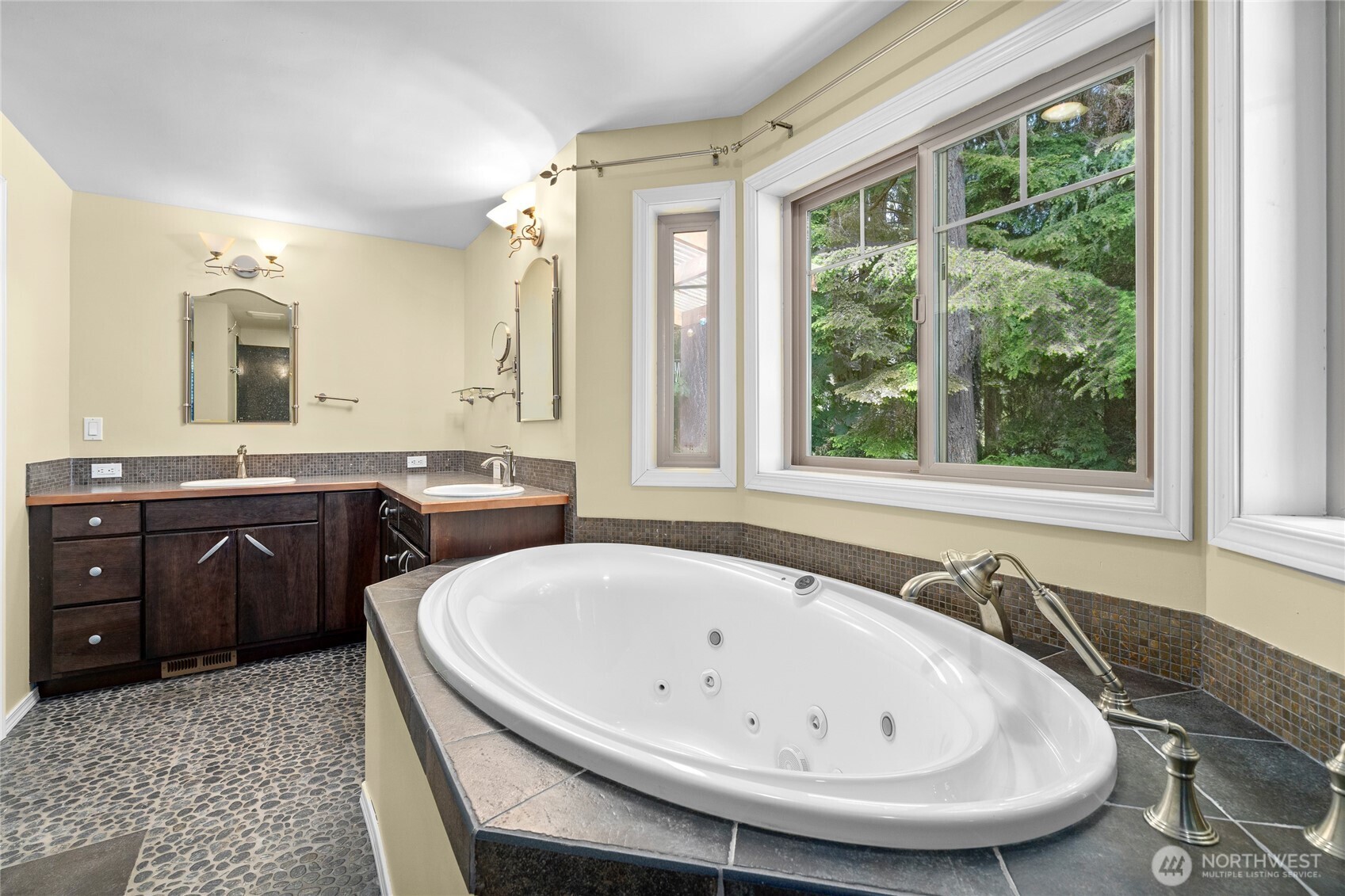 Primary bath with jacuzzi tub, walk in shower and heated tile floor.
