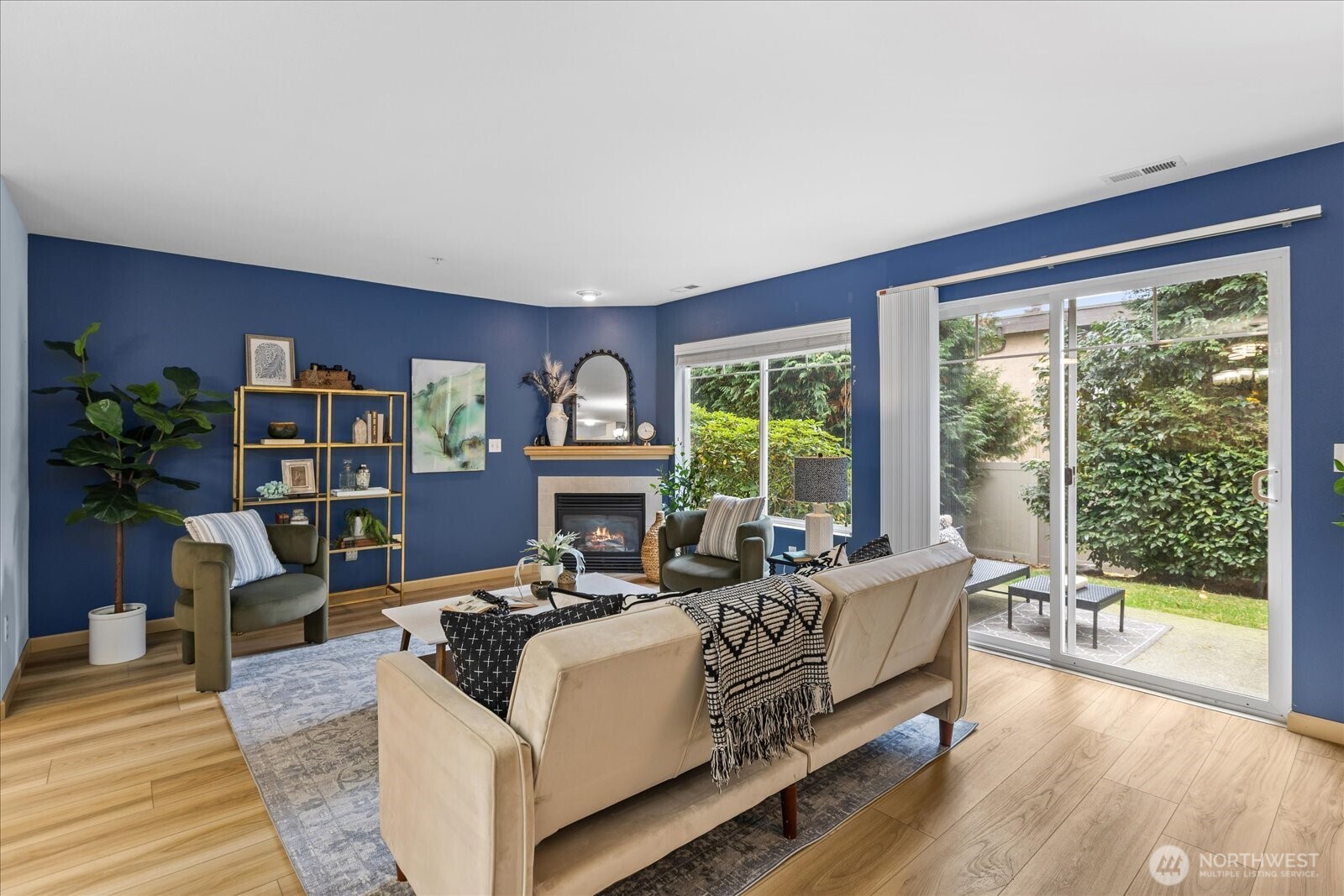 open living room featuring a cozy gas fireplace, creating a warm and comfortable atmosphere. Outside, a charming and quaint patio area is also captured, suggesting an enjoyable outdoor space.