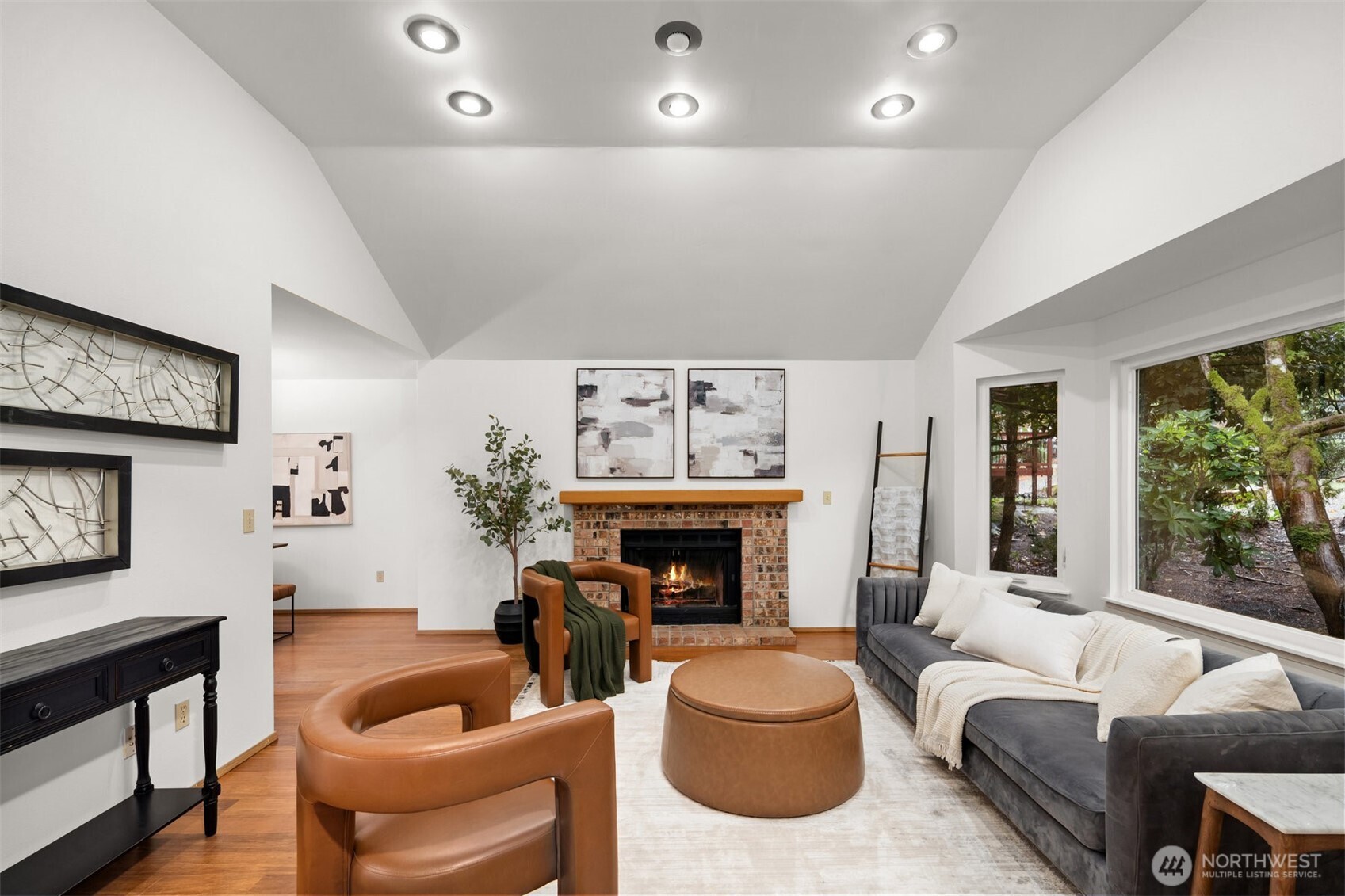 Living room with vaulted ceilings and wood buring fireplace.