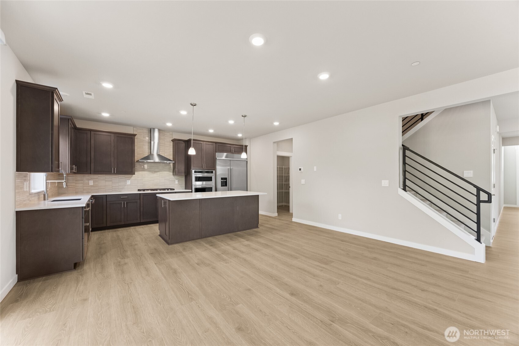 Well-appointed kitchen with gas cooktop, huge pantry adjacent to mud room just off the garage.  48" counter depth side-by-side refrigerator.  Plenty of space to entertain!   Showing a similar floorplan, the walk-through pantry leads to the 2-story formal dining room.