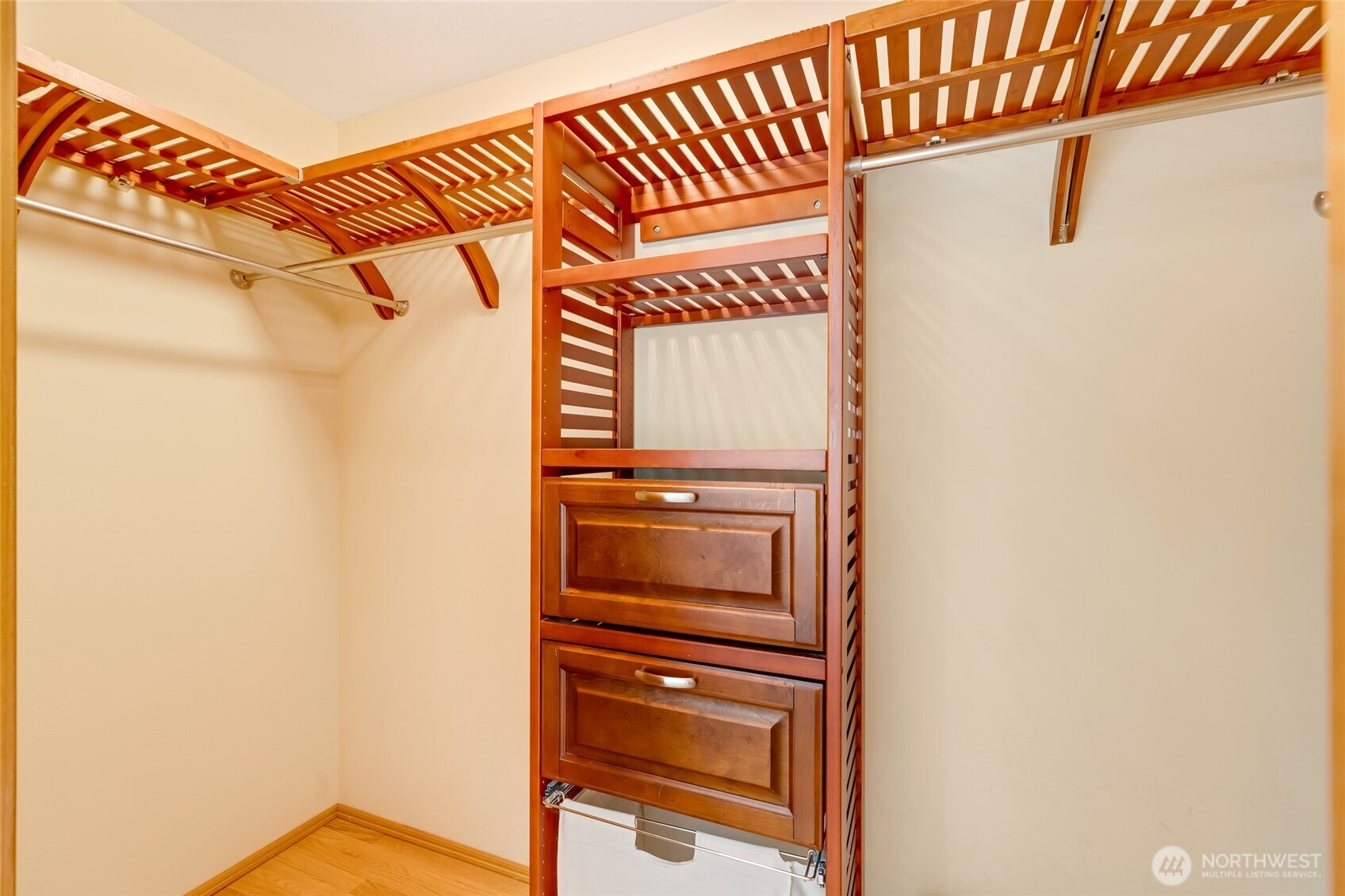 Custom closet system with built-in drawers, shelving, and double hanging space for efficient organization and storage.