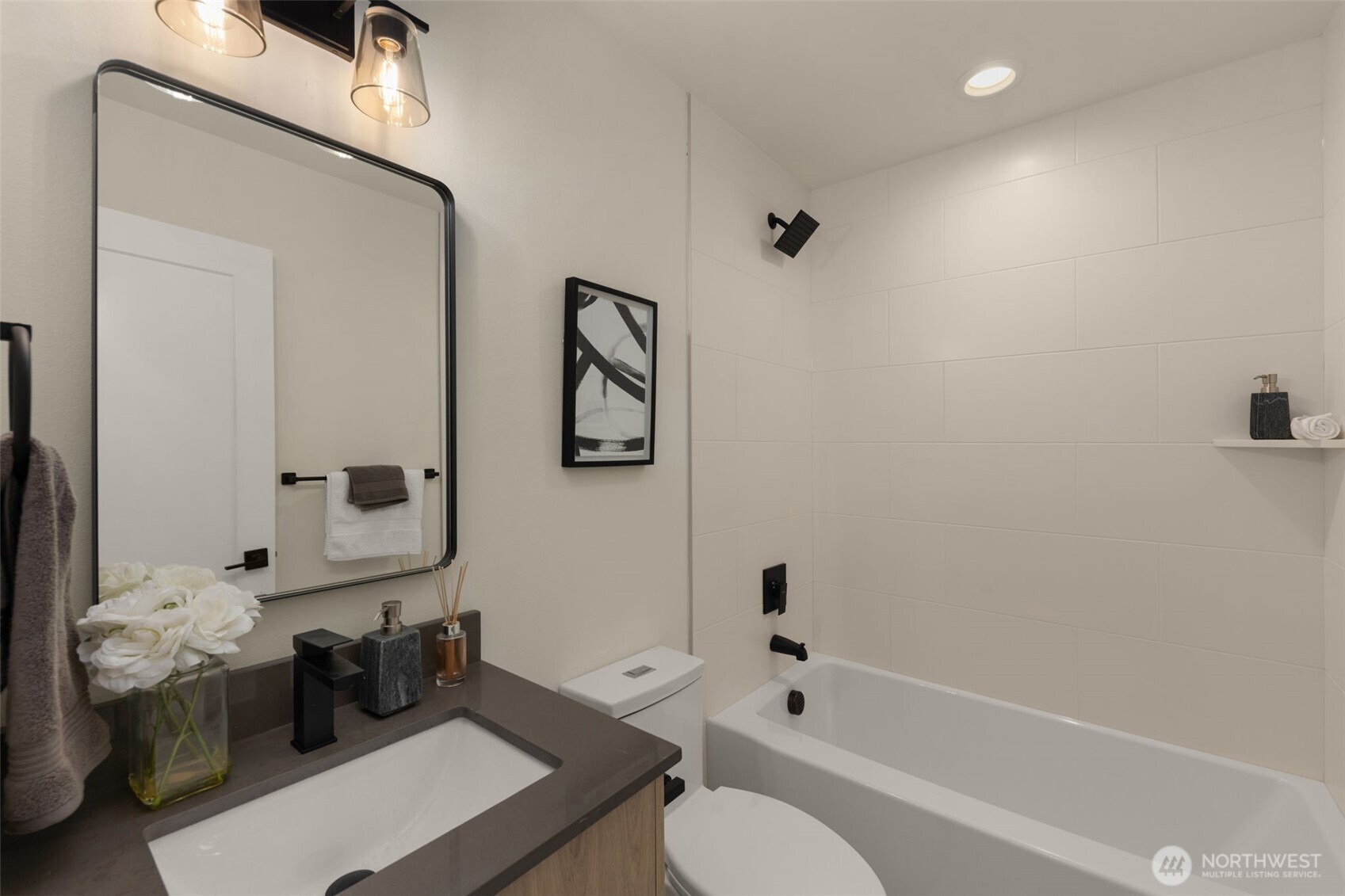 Polished mirrors, refined hardware, and rich cabinetry come together in this beautifully composed bathroom.
