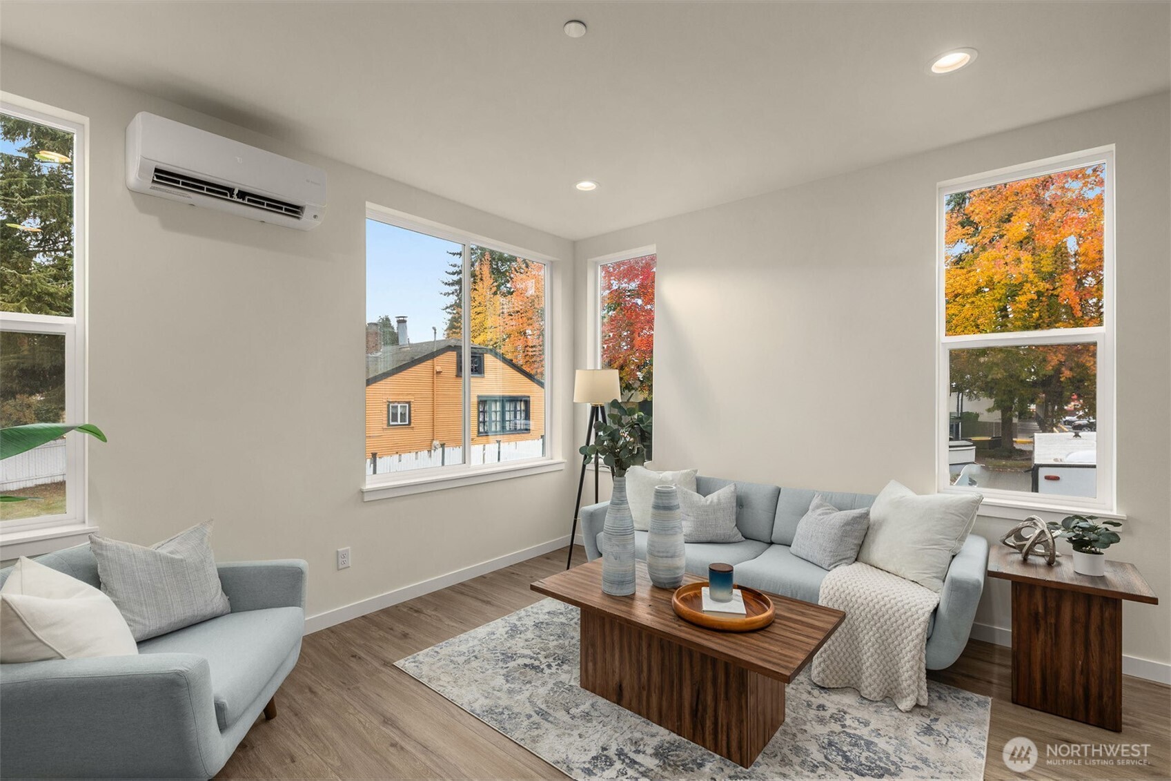 Expansive windows frame leafy neighborhood views, filling the space with golden light and highlighting the home’s timeless design.